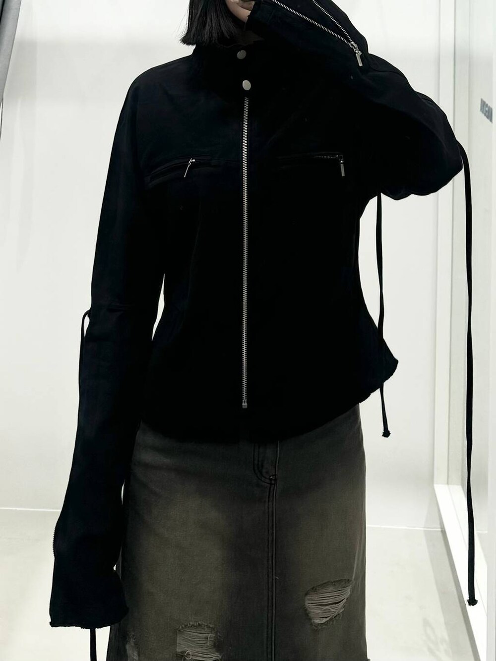 グレー系のデニムスカート、ブラック系のブルゾンを着用したレディースの秋コーディネートの2枚目の写真