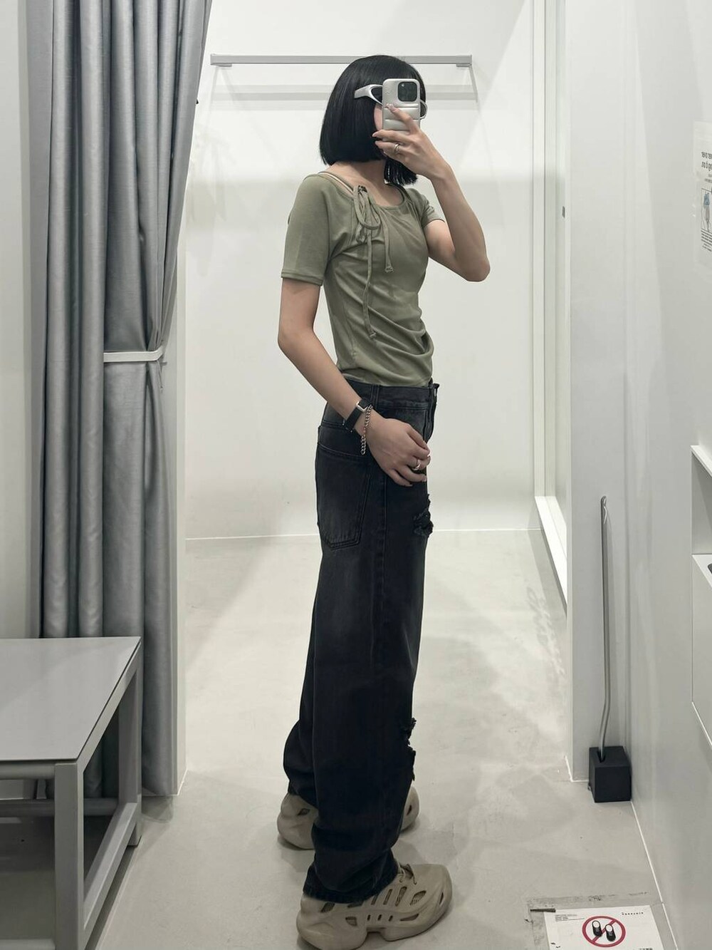 ブラック系のデニムパンツ、ブラック系のショルダーバッグ、グリーン系のTシャツ/カットソーを着用したレディースの夏コーディネートの2枚目の写真