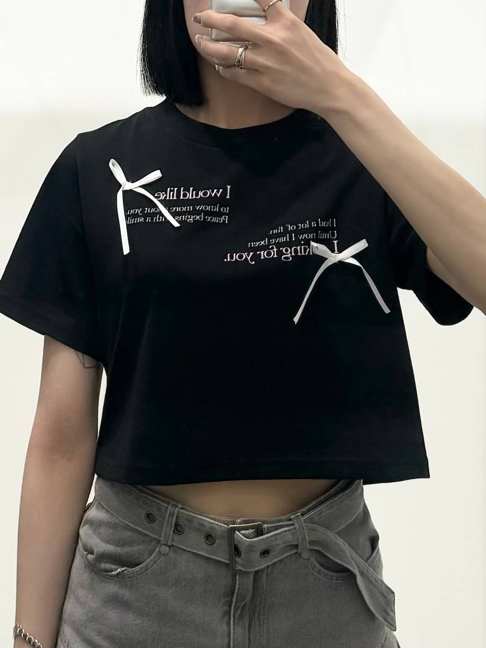 グレー系のデニムスカート、ブラック系のTシャツ/カットソーを着用したレディースの春コーディネートの3枚目の写真