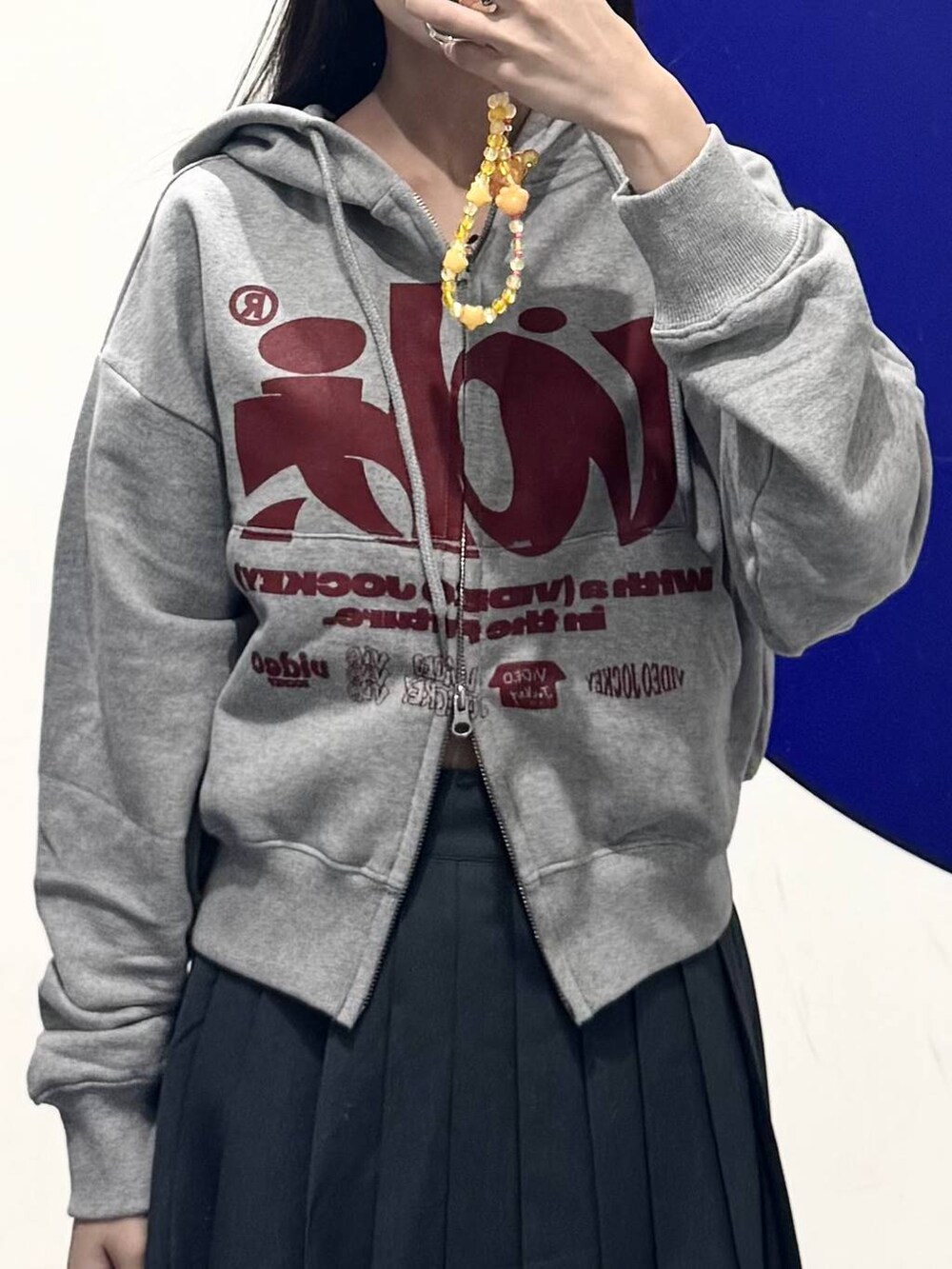 グレー系のパーカー、グレー系のスラックス、グレー系のスカートを着用したレディースの秋コーディネートの3枚目の写真