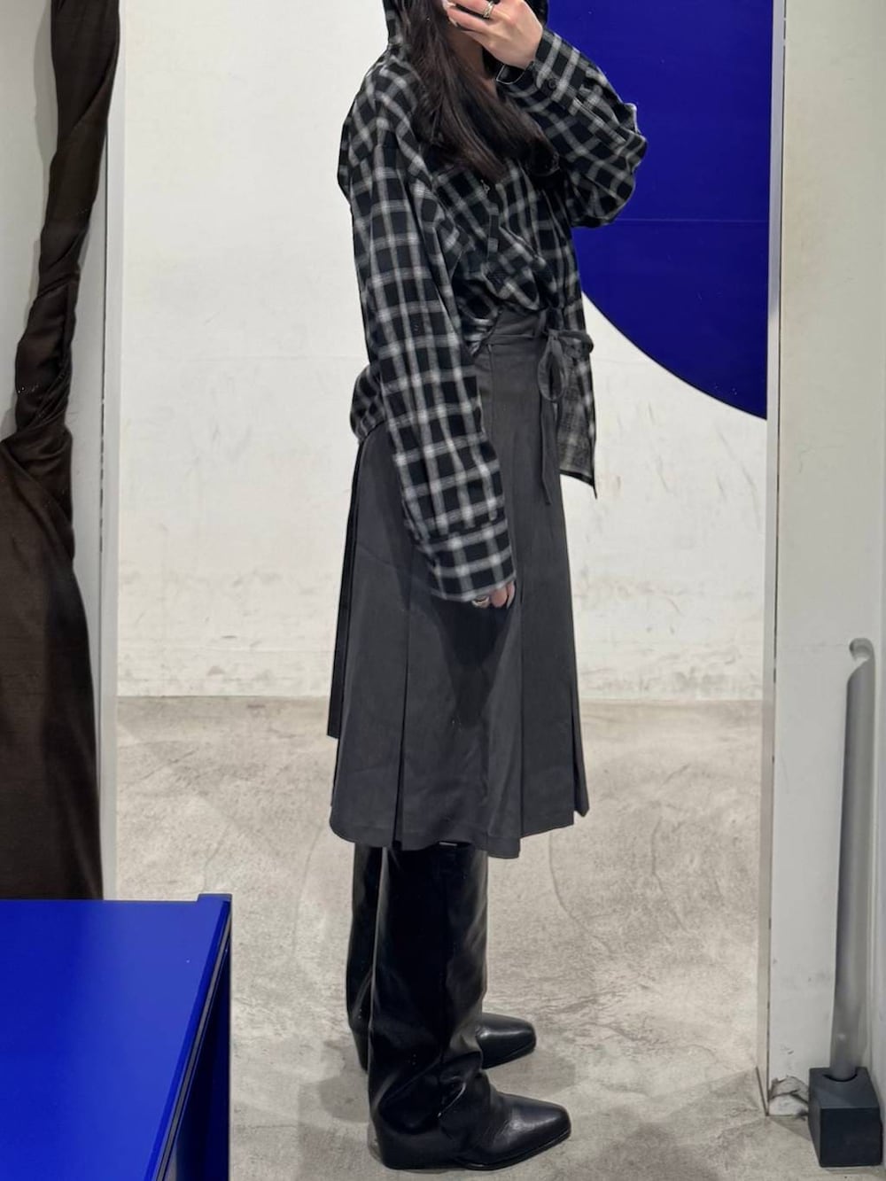 ブラック系のブーツ、グレー系のスカート、ブラック系のシャツ/ブラウスを着用したレディースの春コーディネートの2枚目の写真