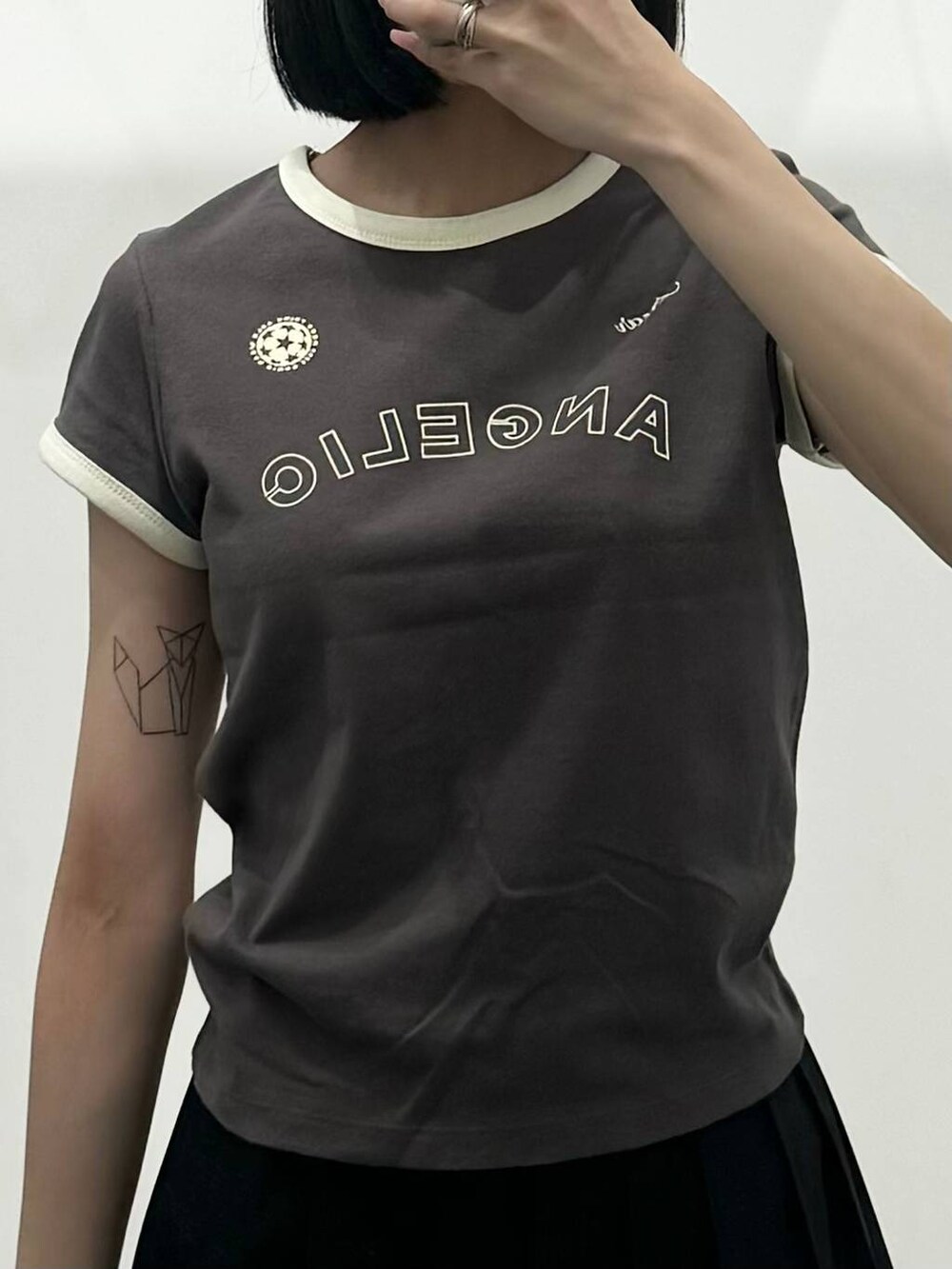 ブラック系のスカート、グレー系のTシャツ/カットソー、ブラック系のブーツを着用したレディースの夏コーディネートの3枚目の写真