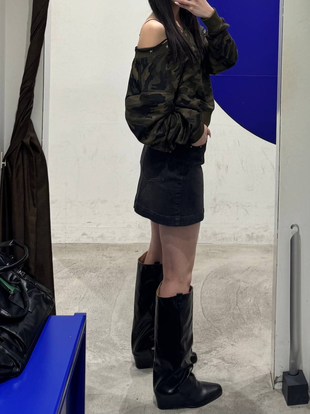 ブラック系のブーツ、ブラック系のデニムスカートを着用したレディースの冬コーディネートの2枚目の写真