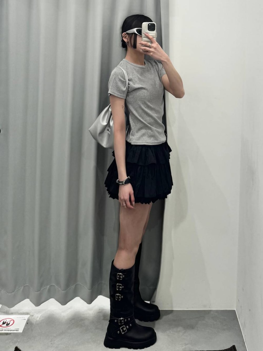 ブラック系のブーツ、グレー系のTシャツ/カットソー、ブラック系のスカートを着用したレディースの春コーディネートの2枚目の写真