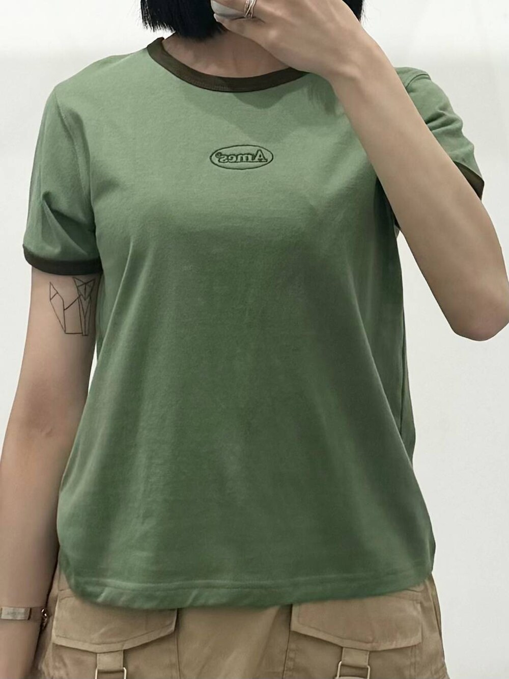 ベージュ系のスカート、グリーン系のTシャツ/カットソーを着用したレディースの春コーディネートの3枚目の写真