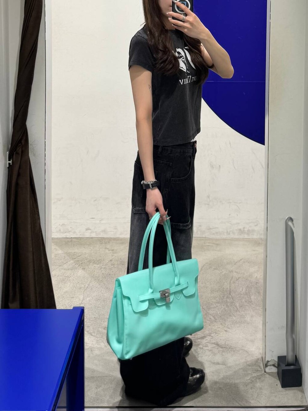 ブラック系のカーゴパンツ、ブラック系のTシャツ/カットソー、グリーン系のショルダーバッグを着用したレディースの夏コーディネートの2枚目の写真