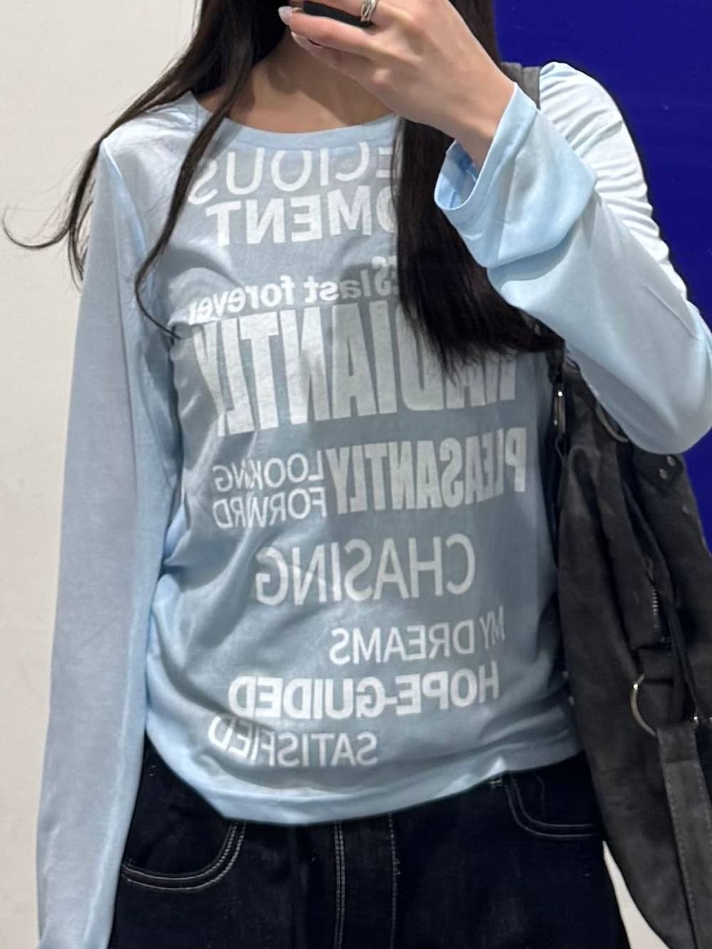 ブルー系のTシャツ/カットソー、ブラック系のデニムパンツ、ブラック系のブーツを着用したレディースの春コーディネートの3枚目の写真