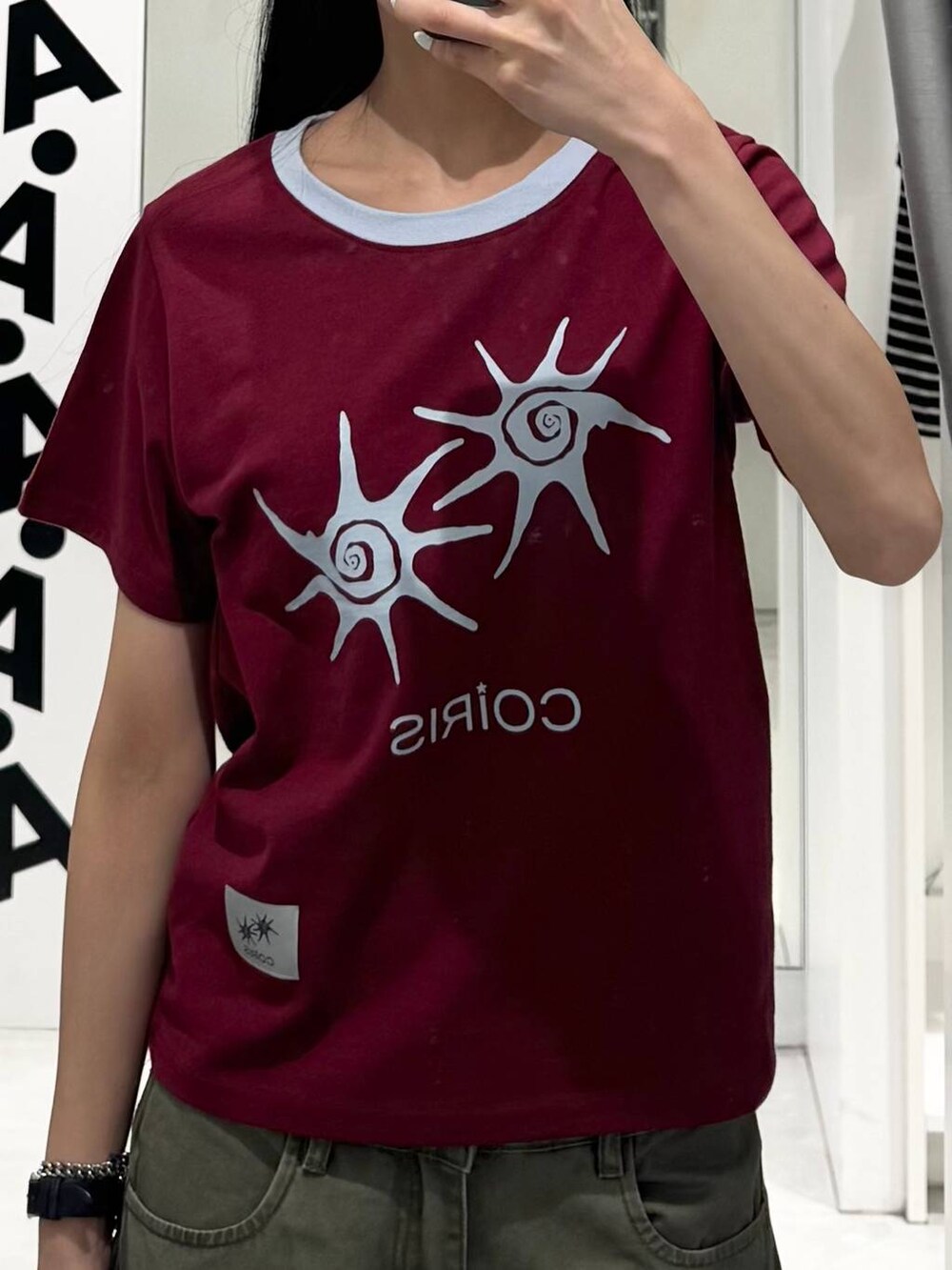 グリーン系のカーゴパンツ、レッド系のTシャツ/カットソーを着用したレディースの夏コーディネートの3枚目の写真