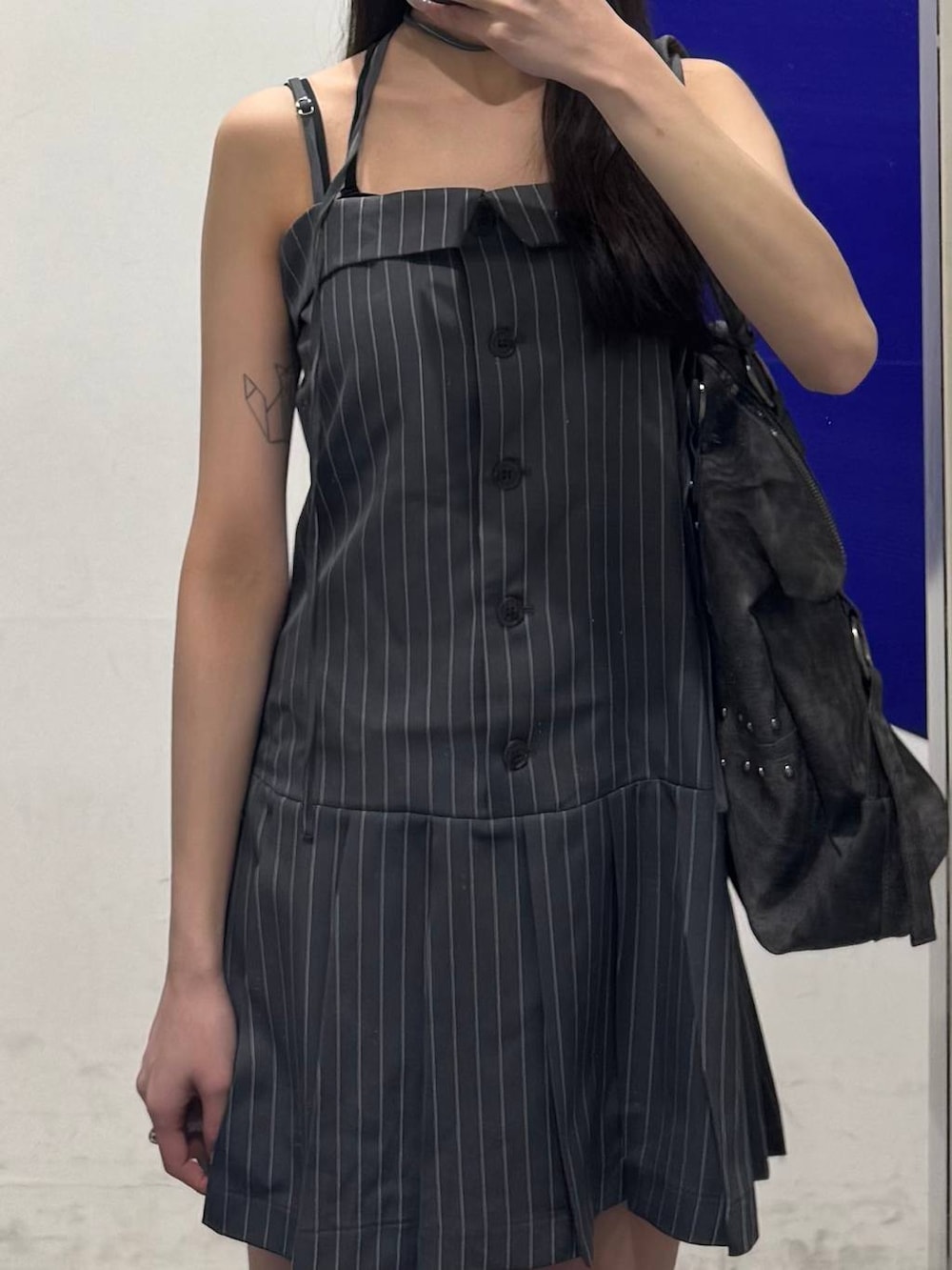 ブラック系のブーツ、グレー系のトートバッグ、グレー系のワンピースを着用したレディースの春コーディネートの3枚目の写真