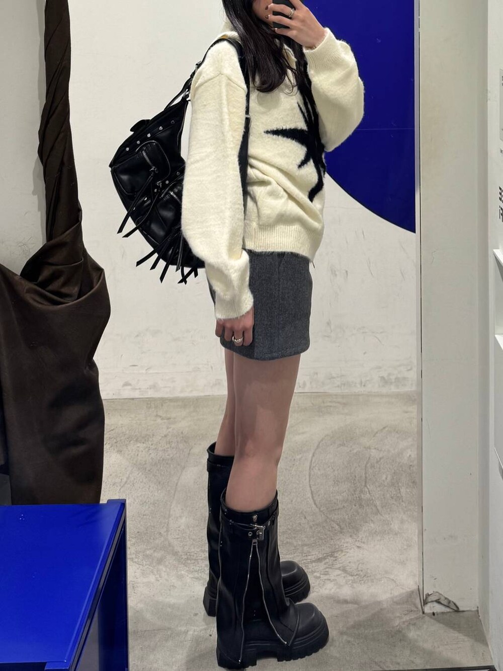 ブラック系のブーツ、グレー系のその他パンツ、ベージュ系のカーディガン/ボレロを着用したレディースの冬コーディネートの2枚目の写真