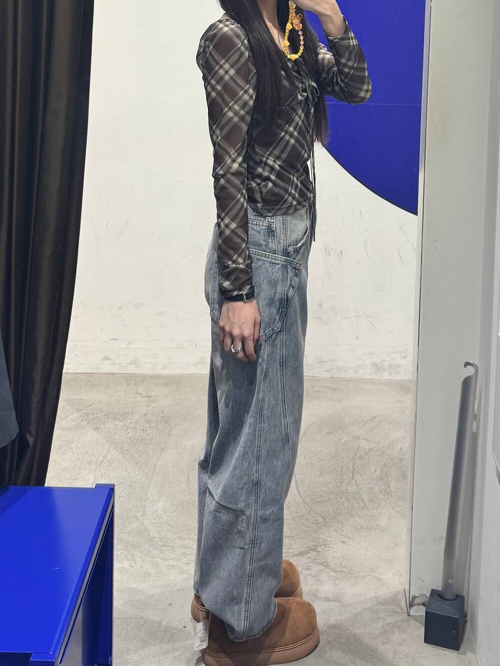 イエロー系のブーツ、ブルー系のデニムパンツ、ブラック系のTシャツ/カットソーを着用したレディースの秋コーディネートの2枚目の写真