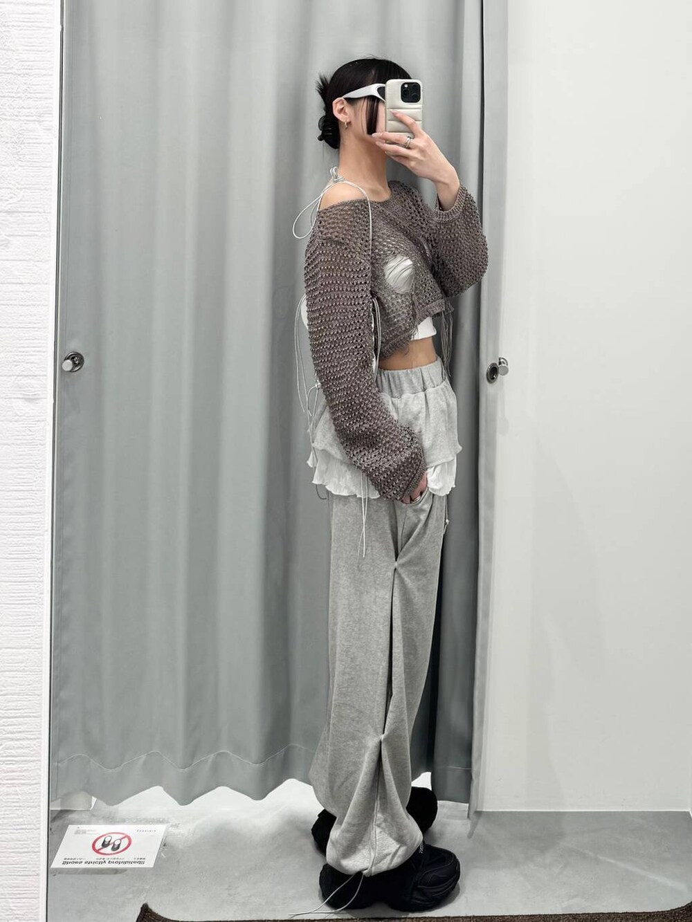 グレー系のニット/セーター、グレー系のスウェットパンツを着用したレディースの春コーディネートの2枚目の写真