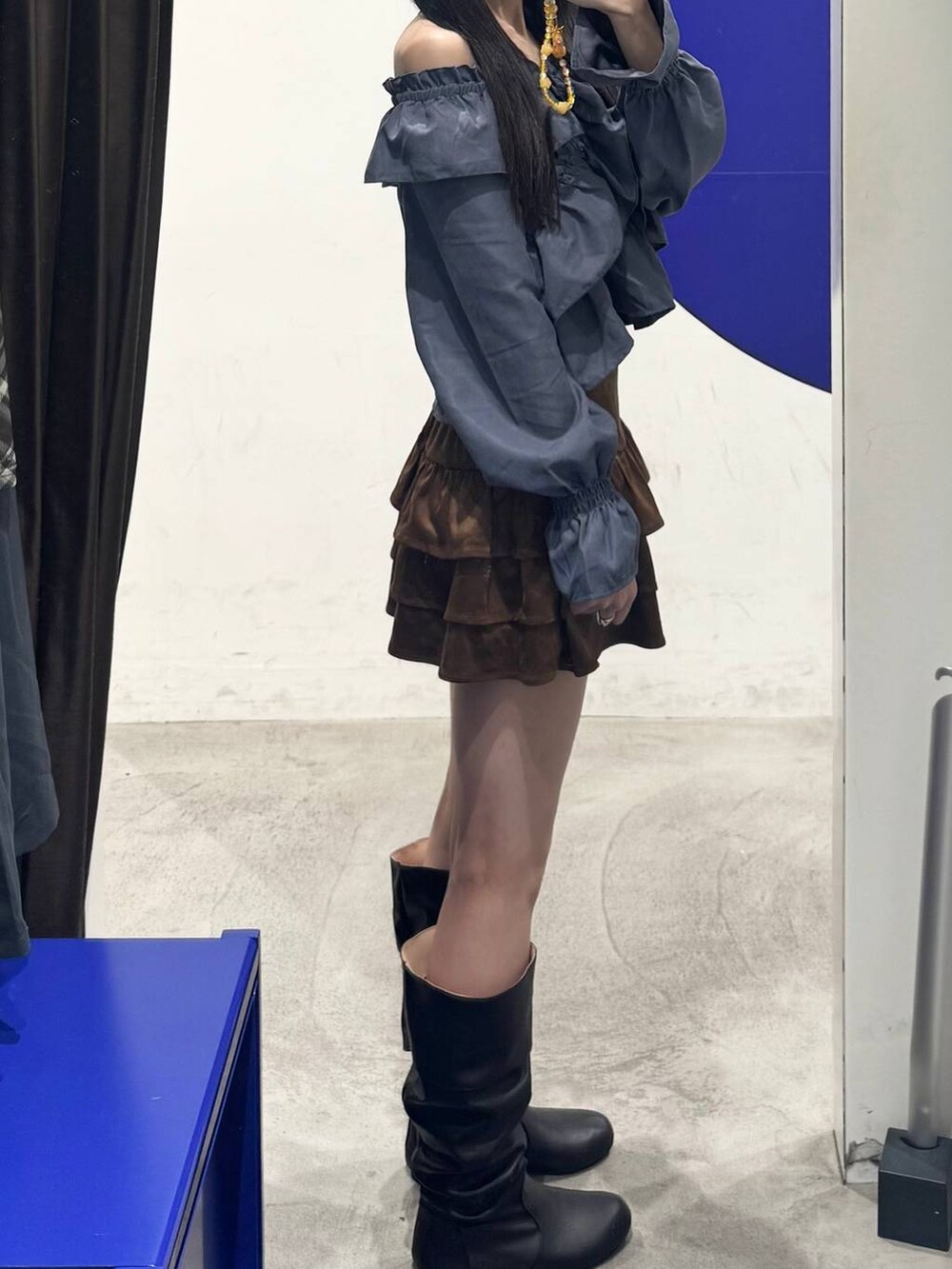 ブラック系のブーツ、ブラウン系のスカート、ブルー系のシャツ/ブラウスを着用したレディースの秋コーディネートの2枚目の写真