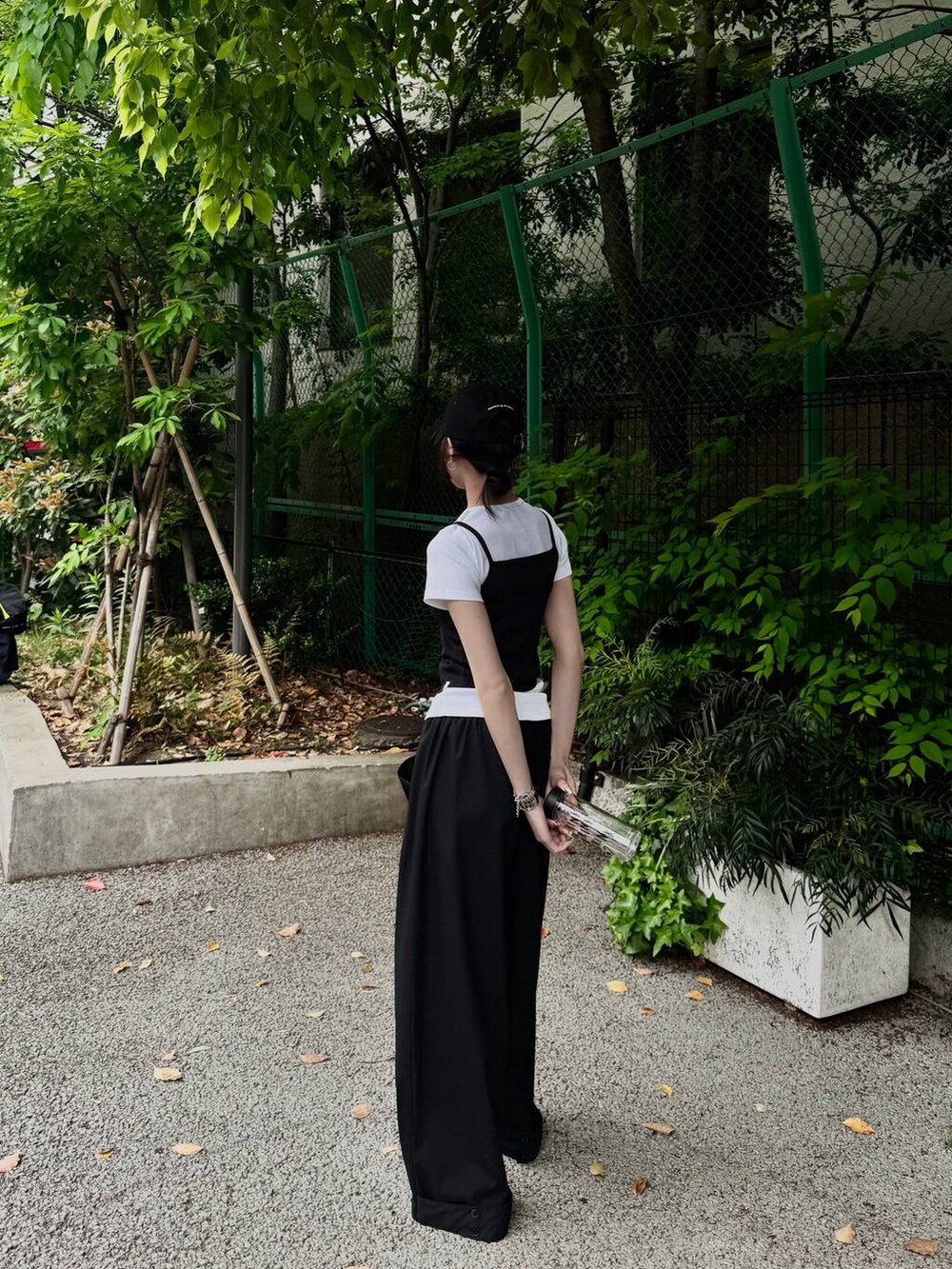 ベージュ系のサンダル、ブラック系のTシャツ/カットソーを着用したレディースの春コーディネートの2枚目の写真