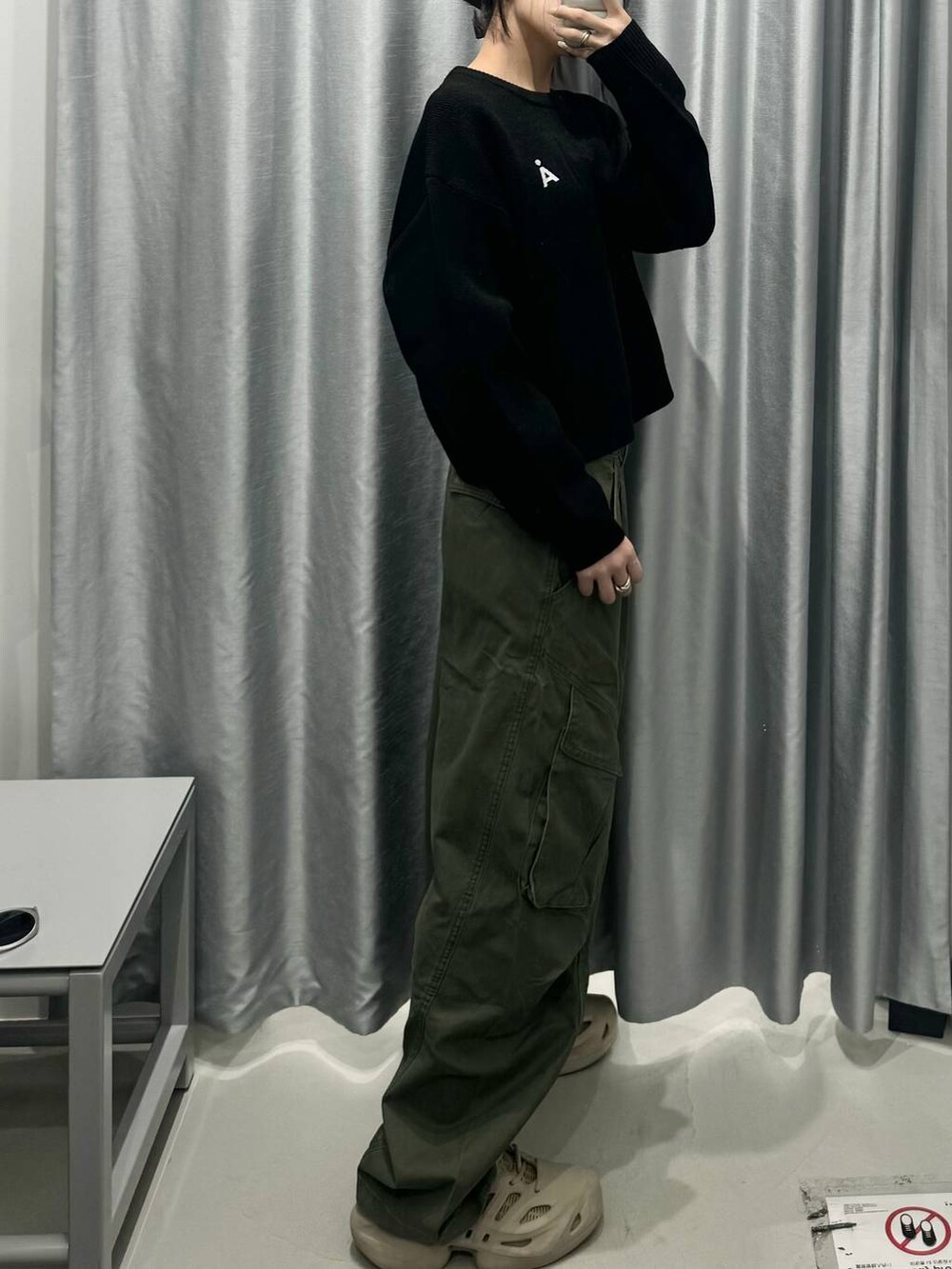 ブラック系のニット/セーター、グリーン系のカーゴパンツを着用したレディースの秋コーディネートの2枚目の写真