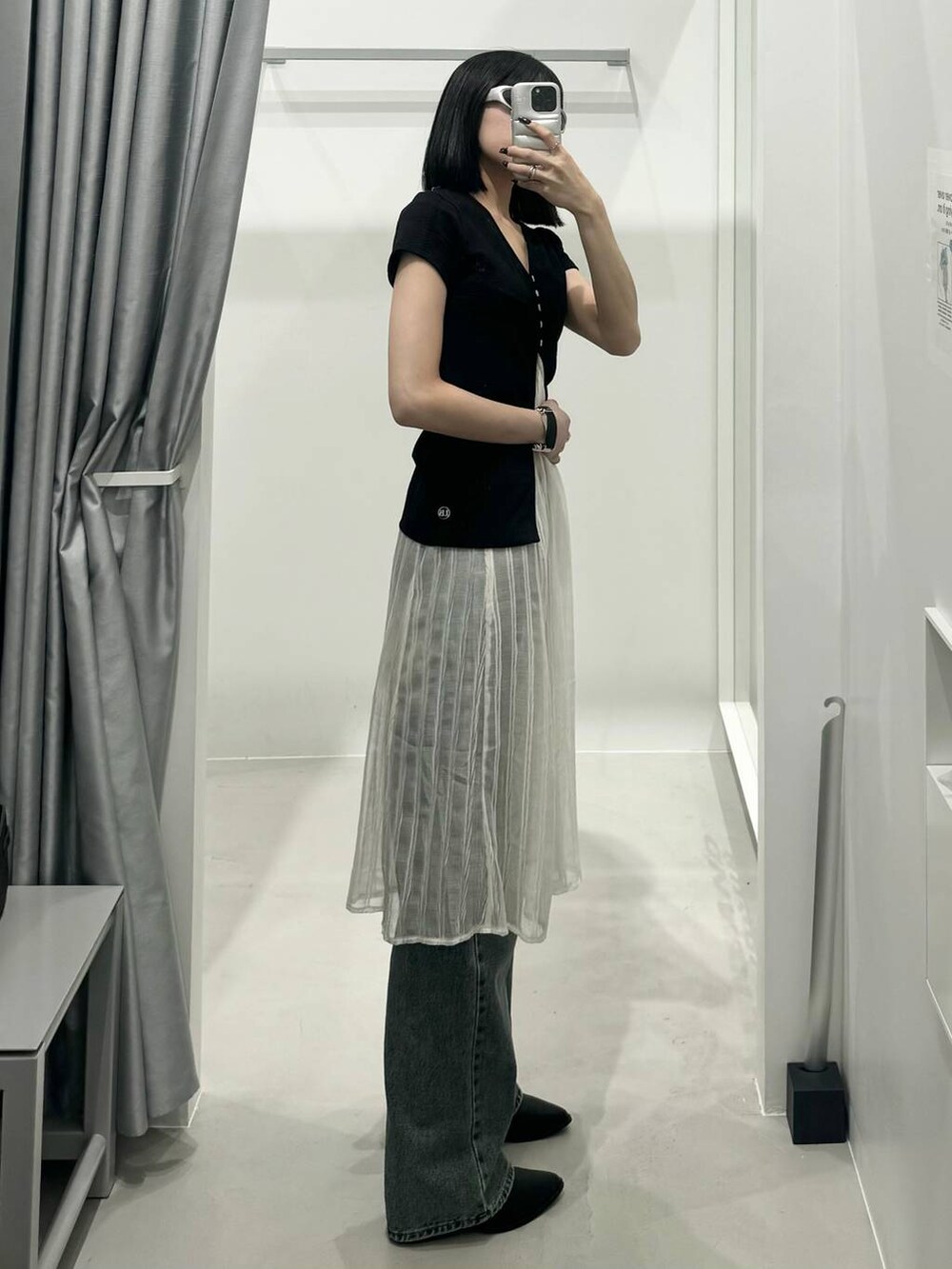 ブルー系のデニムパンツ、ホワイト系のワンピース、ブラック系のカーディガン/ボレロを着用したレディースの夏コーディネートの2枚目の写真