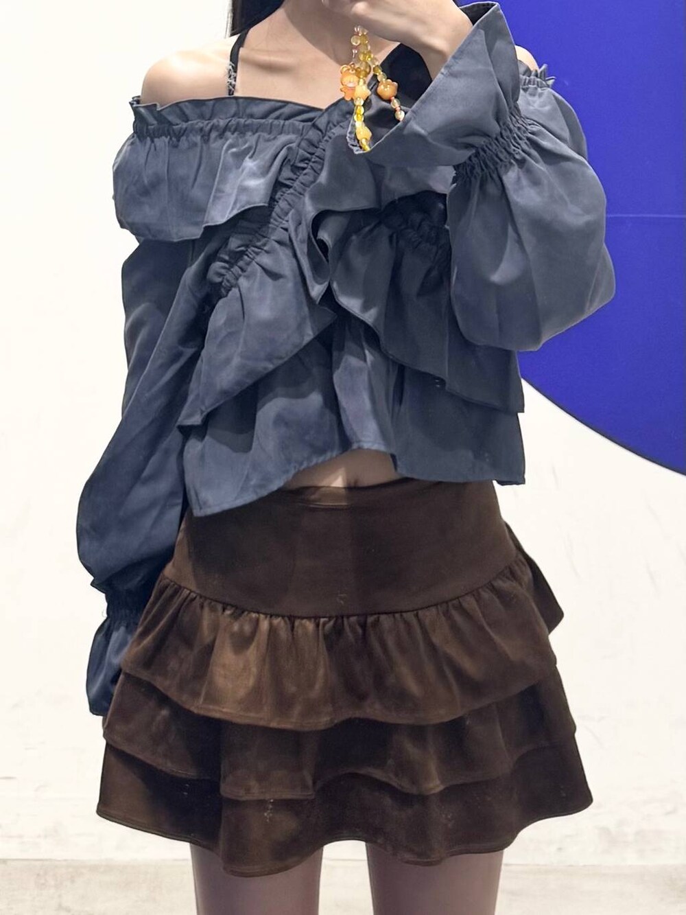 ブラック系のブーツ、ブラウン系のスカート、ブルー系のシャツ/ブラウスを着用したレディースの秋コーディネートの3枚目の写真