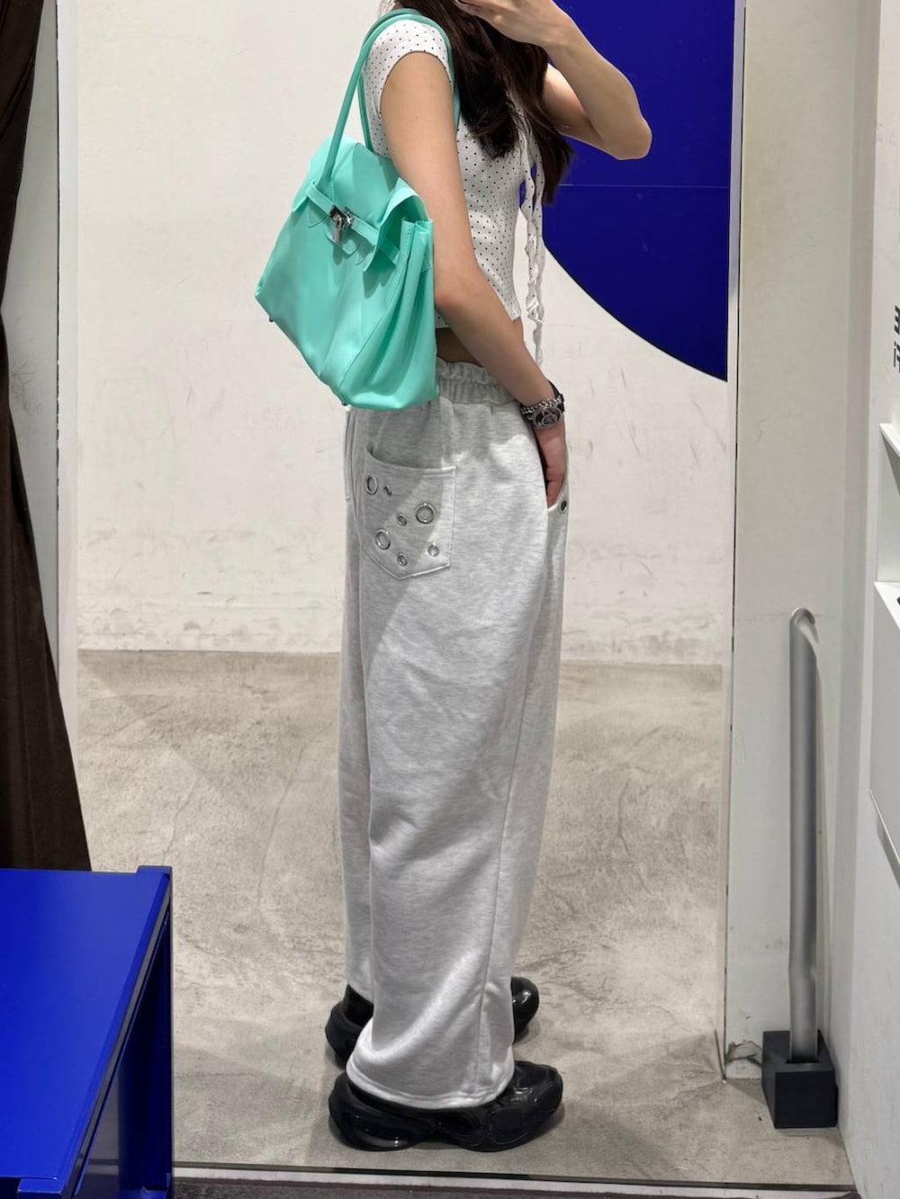ホワイト系のTシャツ/カットソー、グリーン系のショルダーバッグ、ベージュ系のスウェットパンツを着用したレディースの夏コーディネートの2枚目の写真