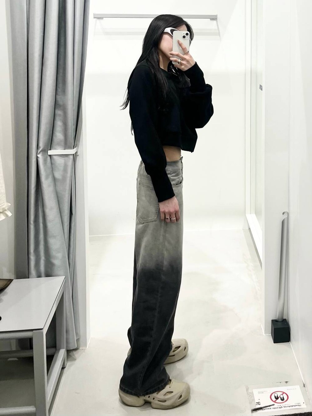 ブラック系のデニムパンツを着用したレディースの春コーディネートの2枚目の写真