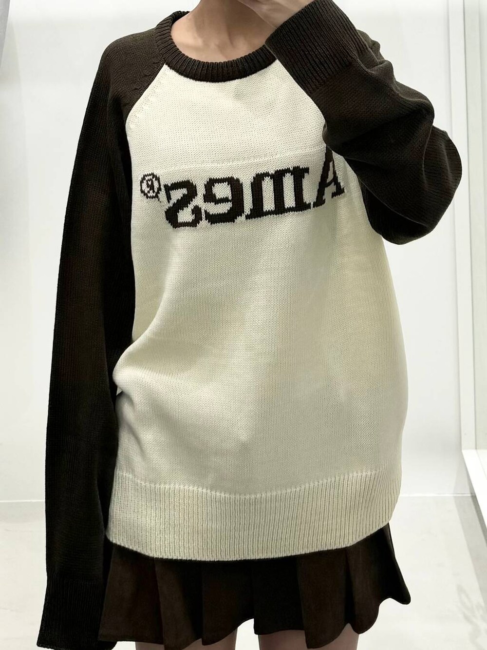 ブラウン系のニット/セーター、ブラウン系のスカート、ブラウン系のブーツを着用したレディースの冬コーディネートの3枚目の写真