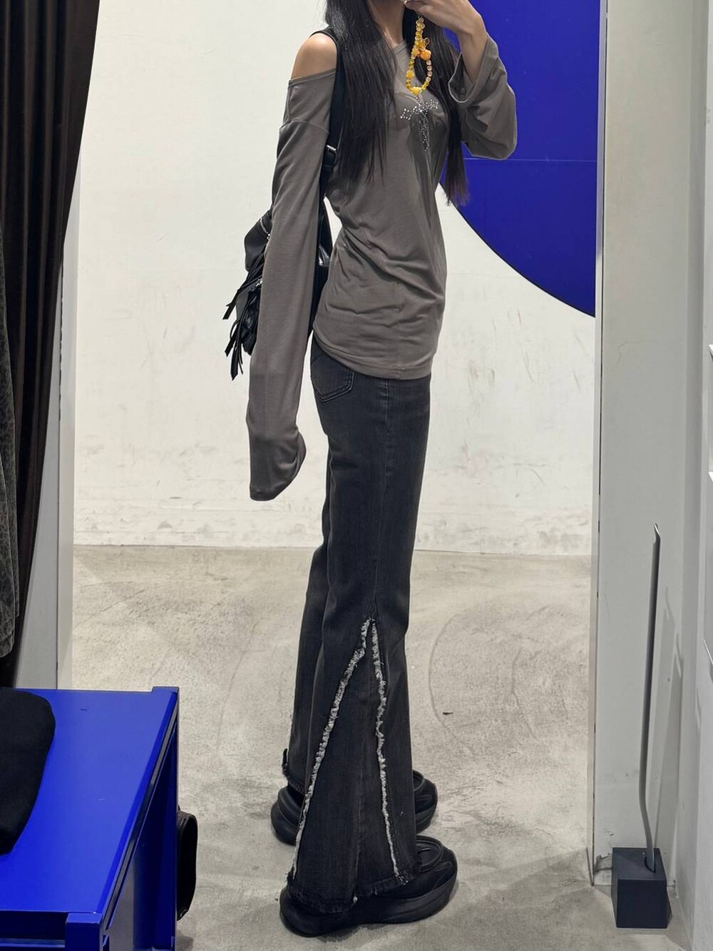 ブラック系のデニムパンツを着用したレディースの秋コーディネートの2枚目の写真