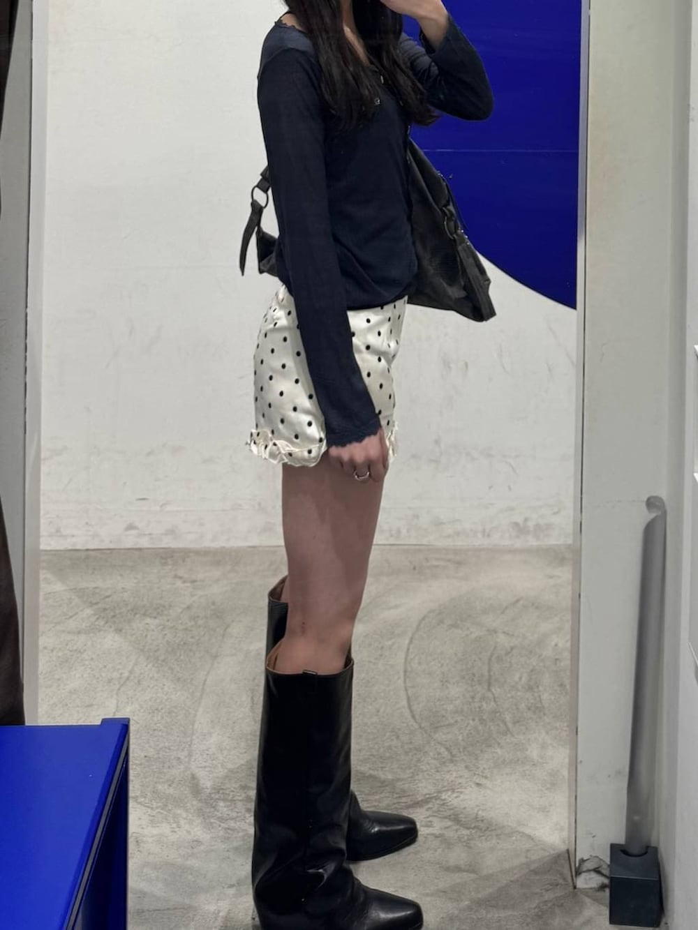 ブラック系のブーツ、グレー系のトートバッグ、ホワイト系のその他パンツを着用したレディースの春コーディネートの2枚目の写真