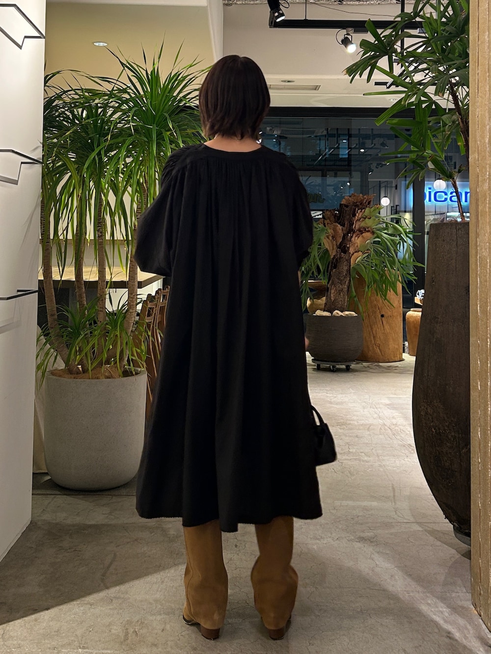 ブラック系のワンピース、イエロー系のブーツ、シルバー系のネックレスを着用したレディースの秋コーディネートの3枚目の写真