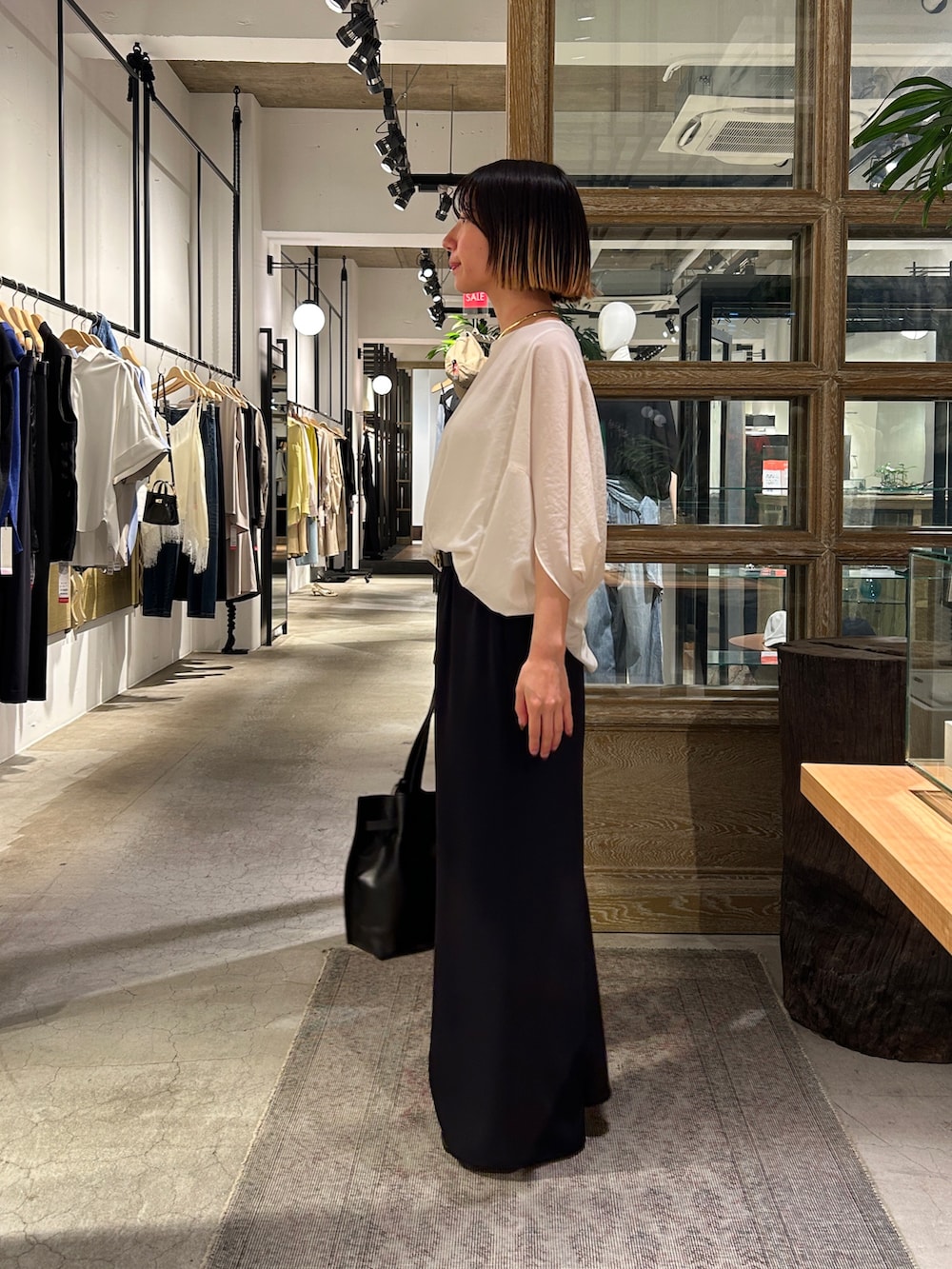 ブラック系のその他パンツ、ホワイト系のシャツ/ブラウス、ブラック系のトートバッグを着用したレディースの夏コーディネートの2枚目の写真