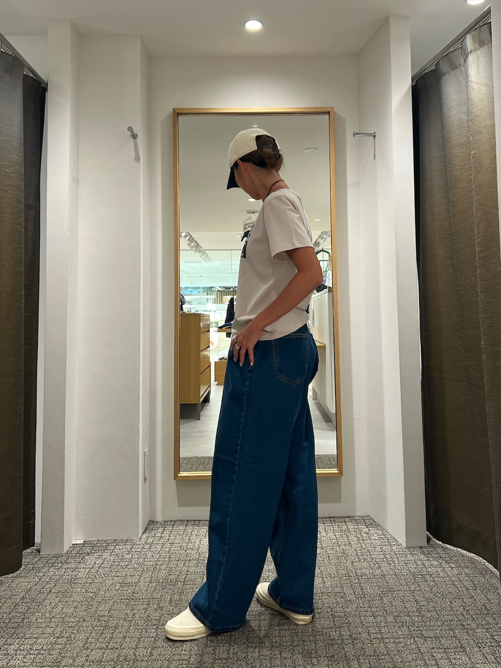 ブルー系のデニムパンツ、ベージュ系のTシャツ/カットソー、ベージュ系のスニーカーを着用したレディースの夏コーディネートの2枚目の写真