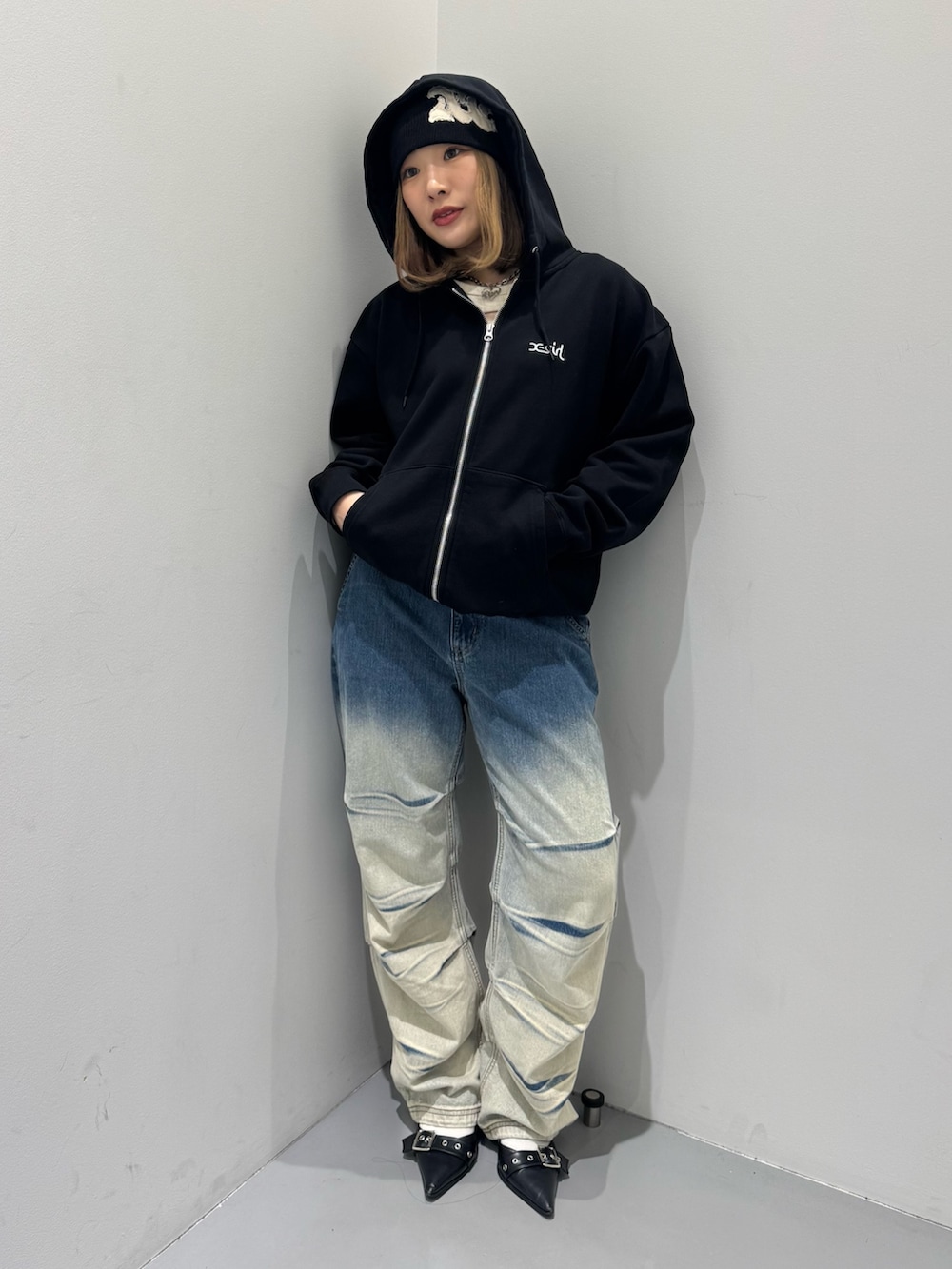 ブルー系のデニムパンツ、ホワイト系のTシャツ/カットソー、ブラック系のパーカーを着用したレディースの冬コーディネートの3枚目の写真