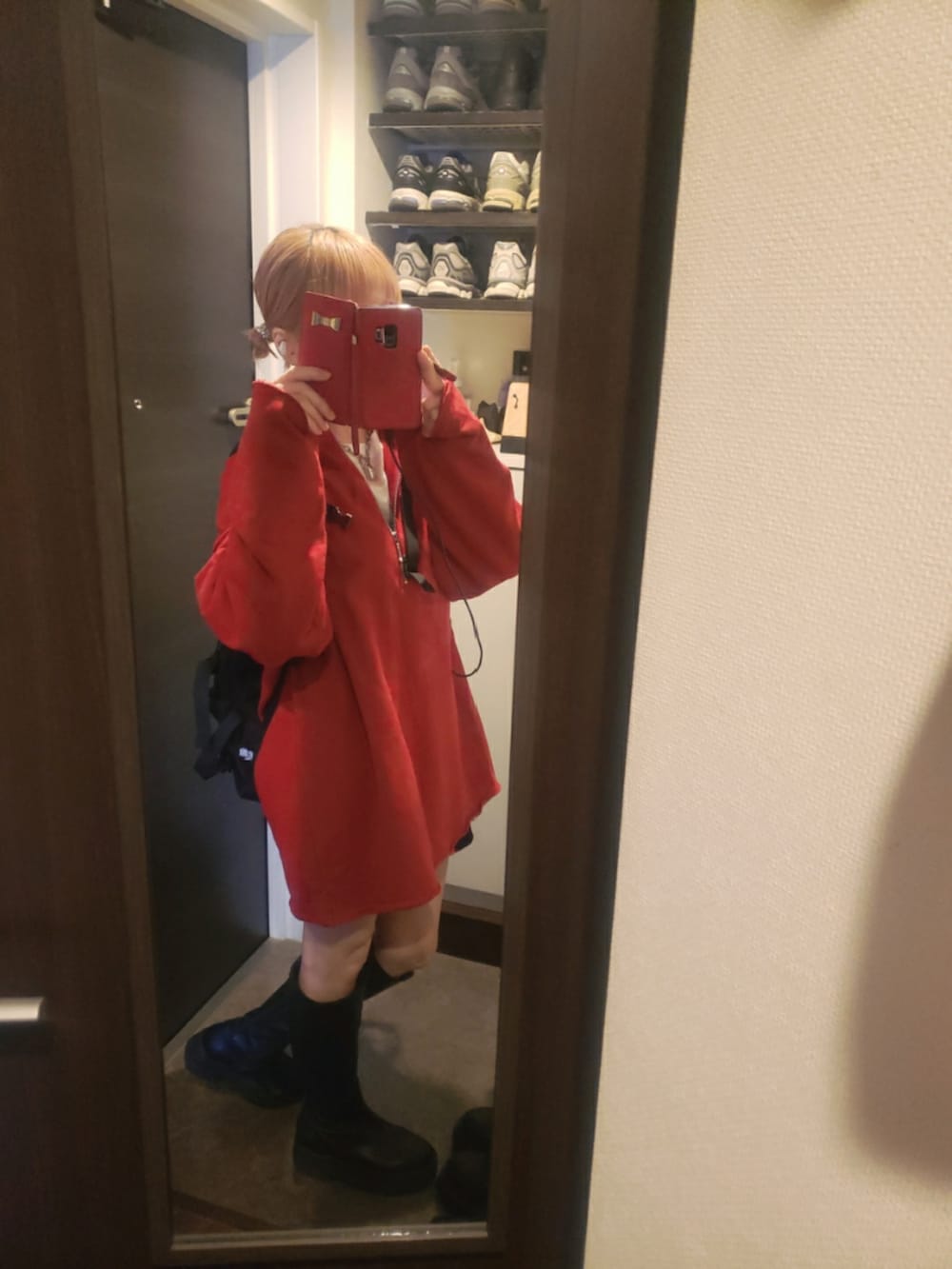 ブラック系のバックパック/リュック、ブラック系のブーツ、レッド系のスウェットを着用したレディースの秋コーディネートの2枚目の写真