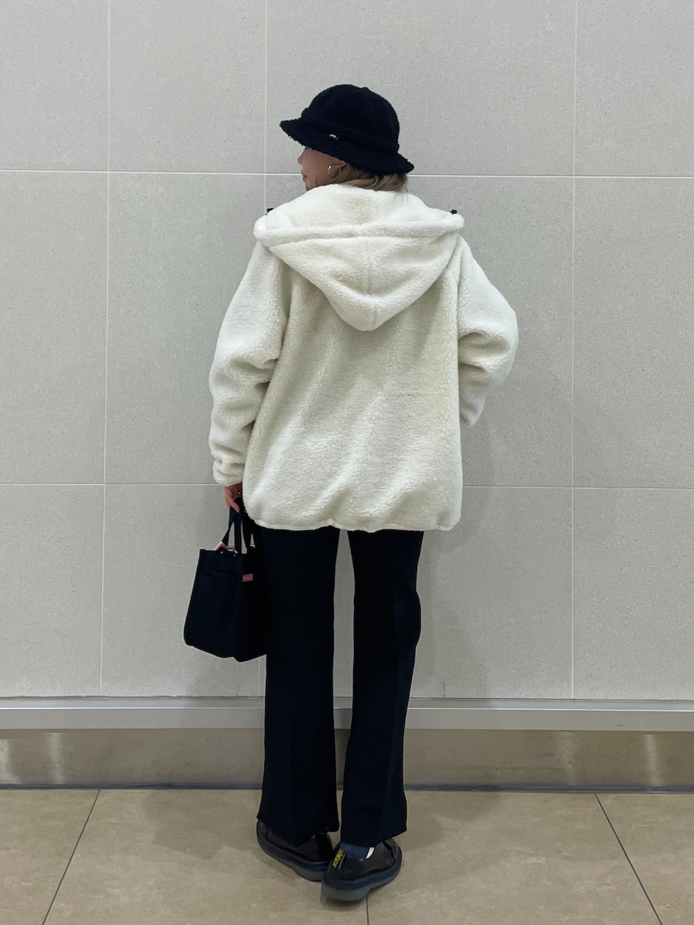 ホワイト系のナイロンジャケット、ブルー系のTシャツ/カットソー、ブラック系のその他パンツを着用したレディースの冬コーディネートの2枚目の写真