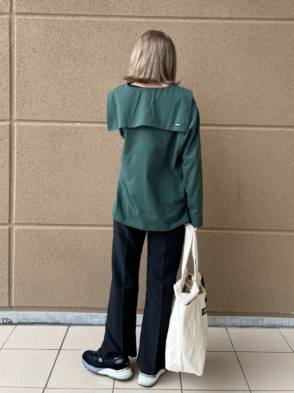 ブラック系のその他パンツ、グリーン系のTシャツ/カットソー、ホワイト系のトートバッグを着用したレディースの冬コーディネートの2枚目の写真