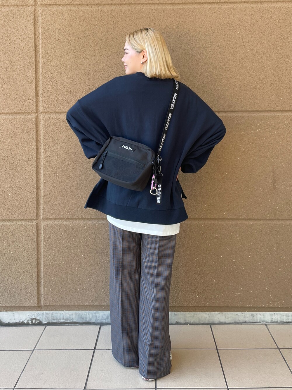ブラック系のショルダーバッグ、ブルー系のスウェット、グレー系のその他パンツを着用したレディースの冬コーディネートの2枚目の写真