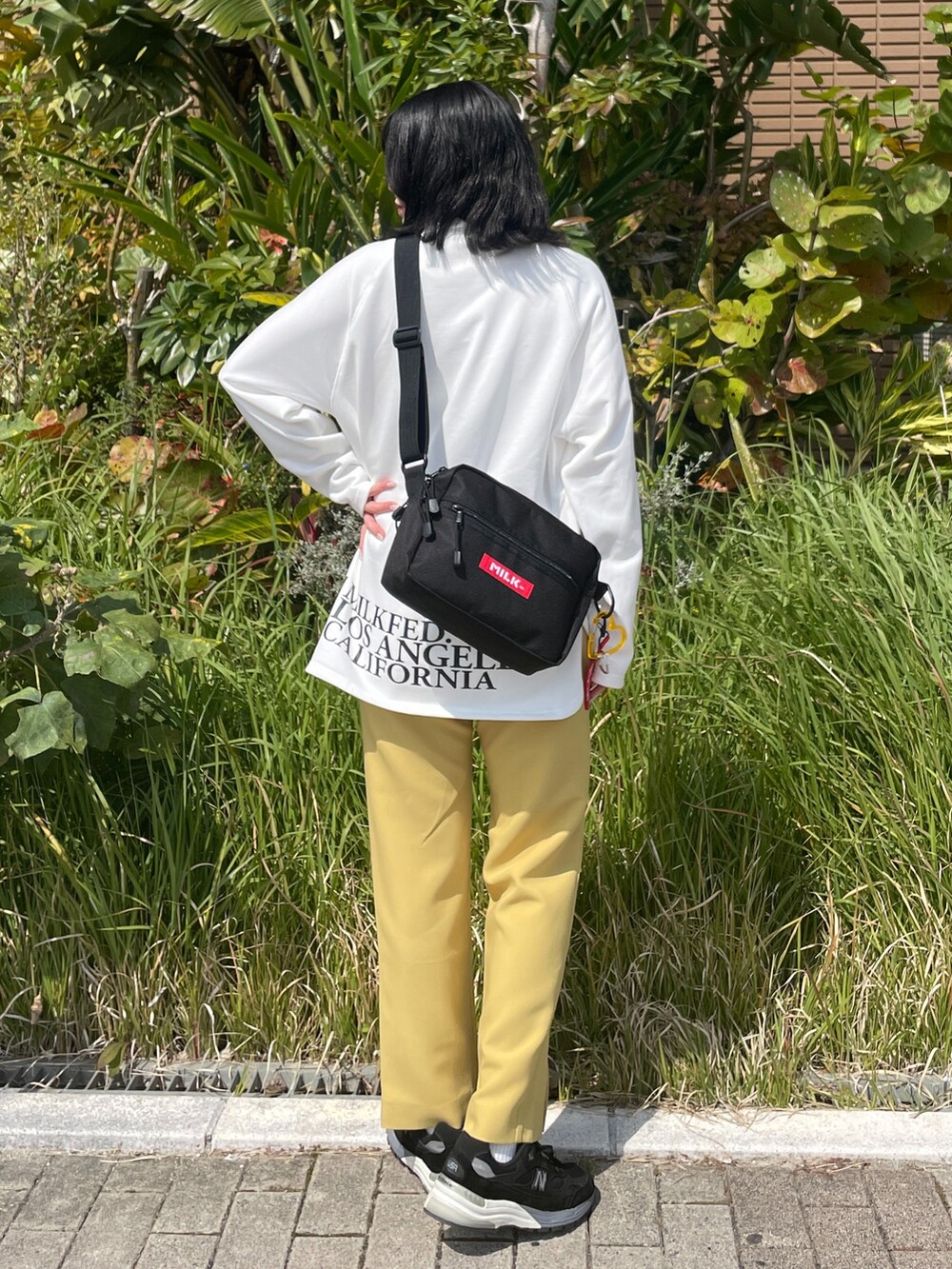 イエロー系のその他パンツ、ホワイト系のTシャツ/カットソー、レッド系のショルダーバッグを着用したレディースの春コーディネートの2枚目の写真