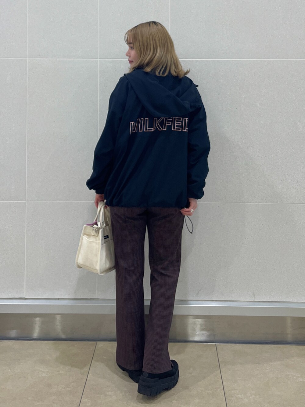 ホワイト系のショルダーバッグ、ブラウン系のその他パンツ、ブラック系のシューズを着用したレディースの冬コーディネートの2枚目の写真