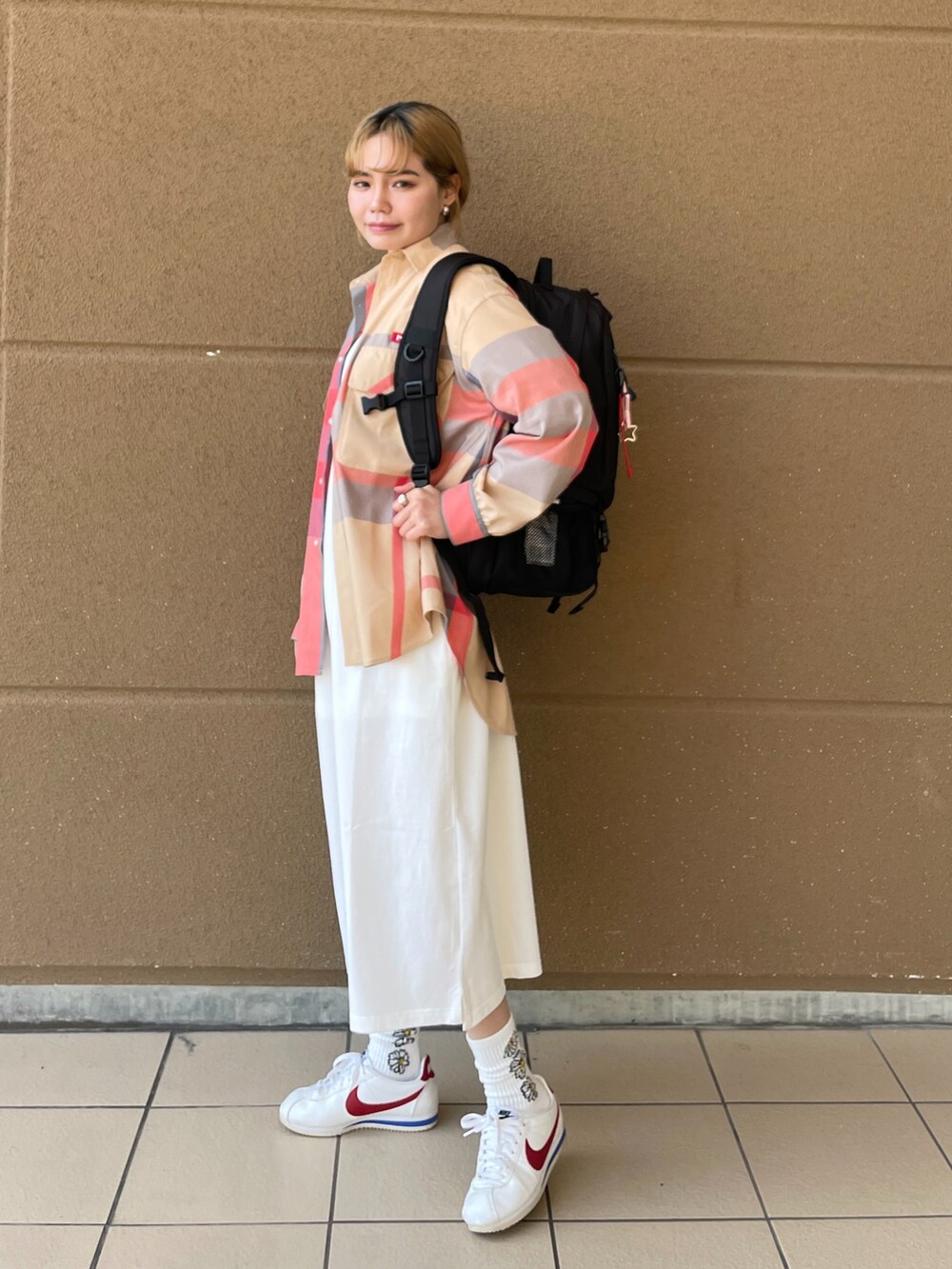 レッド系のバックパック/リュック、ホワイト系のワンピース、ベージュ系のシャツ/ブラウスを着用したレディースの冬コーディネートの2枚目の写真