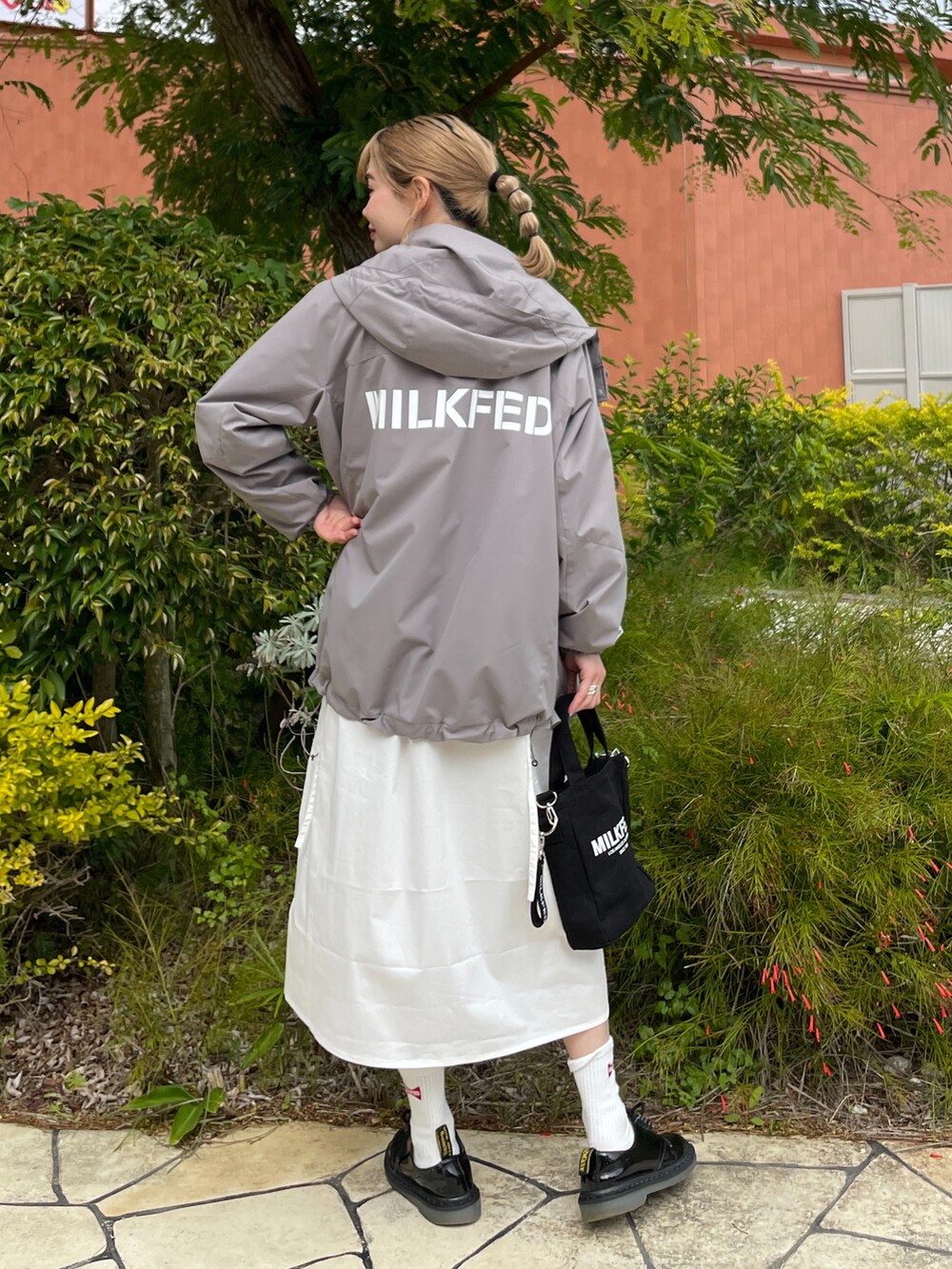 ブラック系のショルダーバッグ、ホワイト系のワンピース、グレー系のブルゾンを着用したレディースの冬コーディネートの2枚目の写真