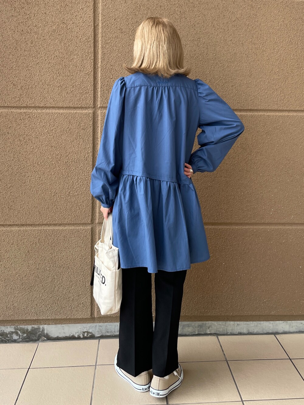 ホワイト系のショルダーバッグ、ブラック系のその他パンツ、ホワイト系のチュニックを着用したレディースの冬コーディネートの2枚目の写真