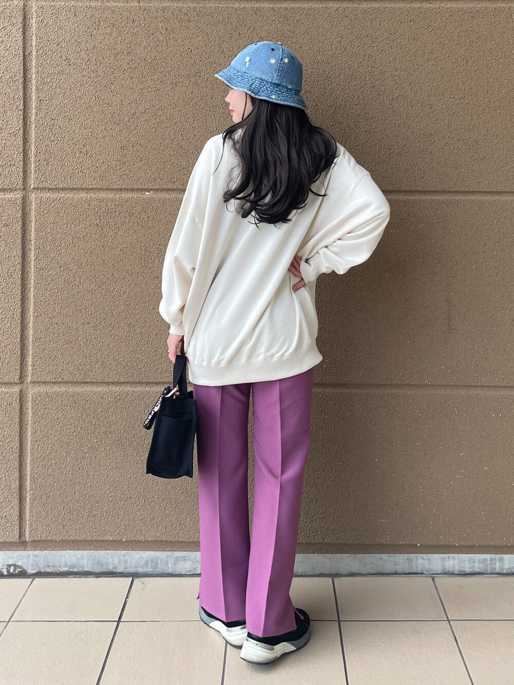 ホワイト系のスウェット、パープル系のその他パンツ、ピンク系のショルダーバッグを着用したレディースの冬コーディネートの2枚目の写真