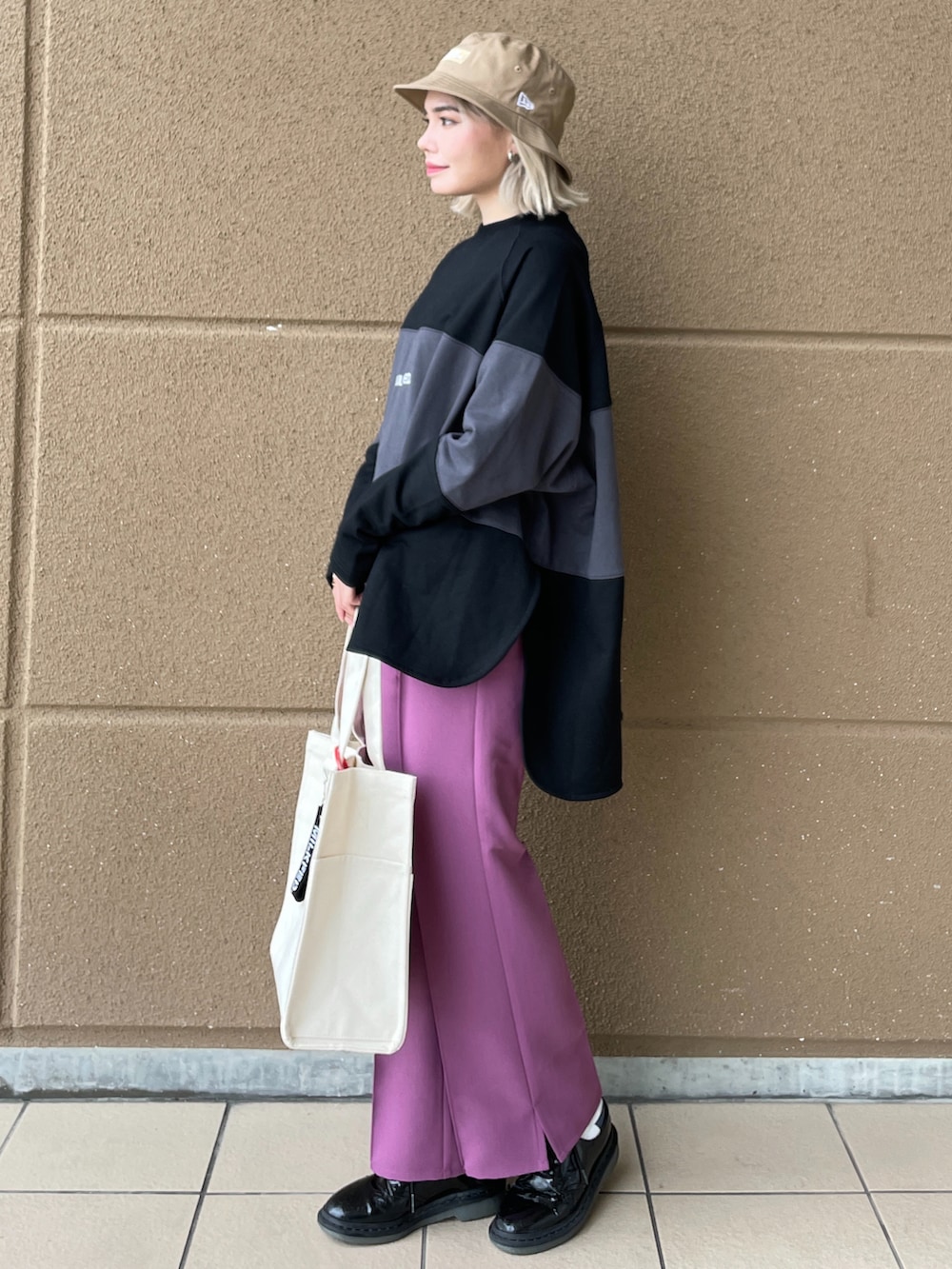 ブラック系のスウェット、パープル系のその他パンツ、ホワイト系のトートバッグを着用したレディースの秋コーディネートの2枚目の写真