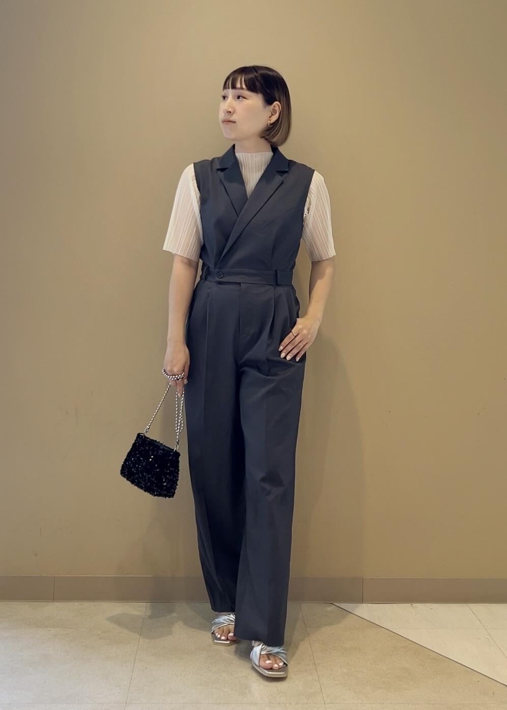 ブラック系のショルダーバッグ、ブラック系のサンダル、ホワイト系のTシャツ/カットソーを着用したレディースの夏コーディネートの4枚目の写真