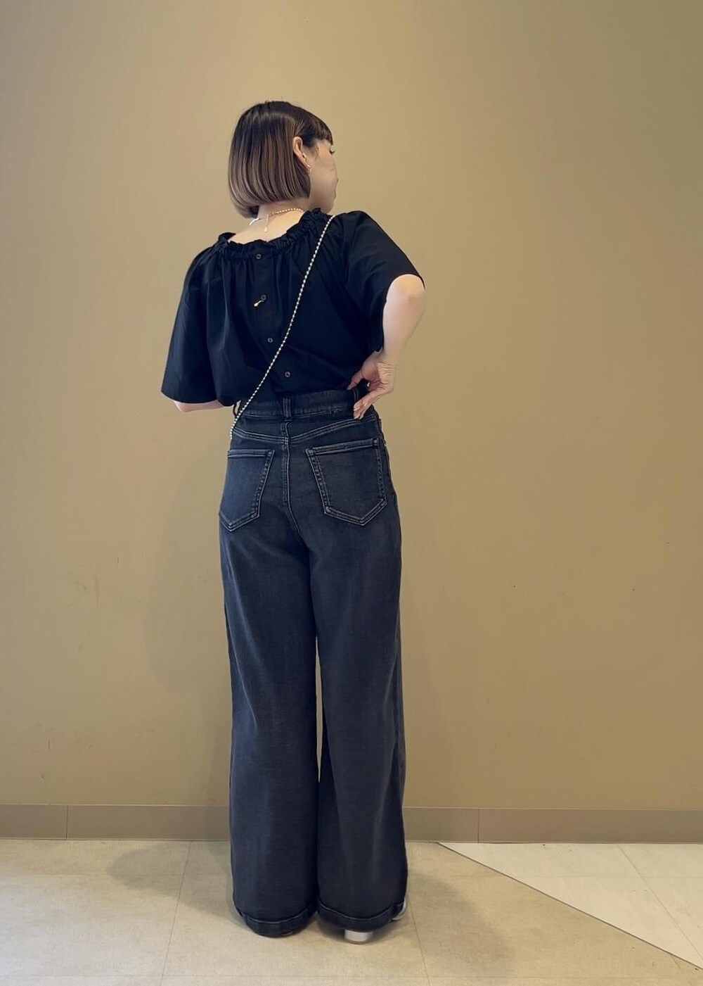 グレー系のショルダーバッグ、シルバー系のサンダル、ブラック系のシャツ/ブラウスを着用したレディースの夏コーディネートの3枚目の写真