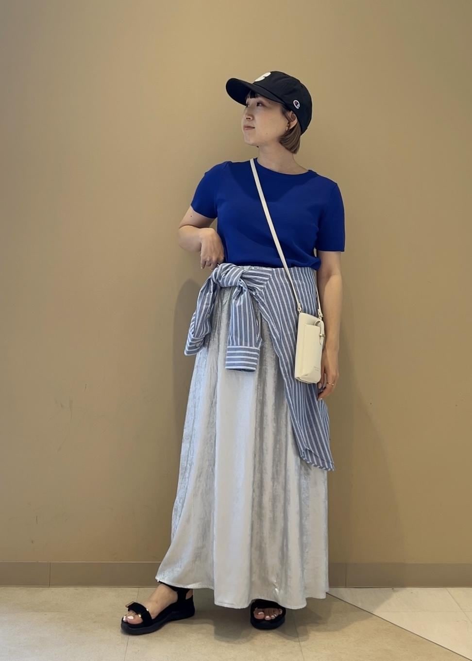 シルバー系のスカート、ブルー系のニット/セーター、ブラック系のサンダルを着用したレディースの夏コーディネートの3枚目の写真