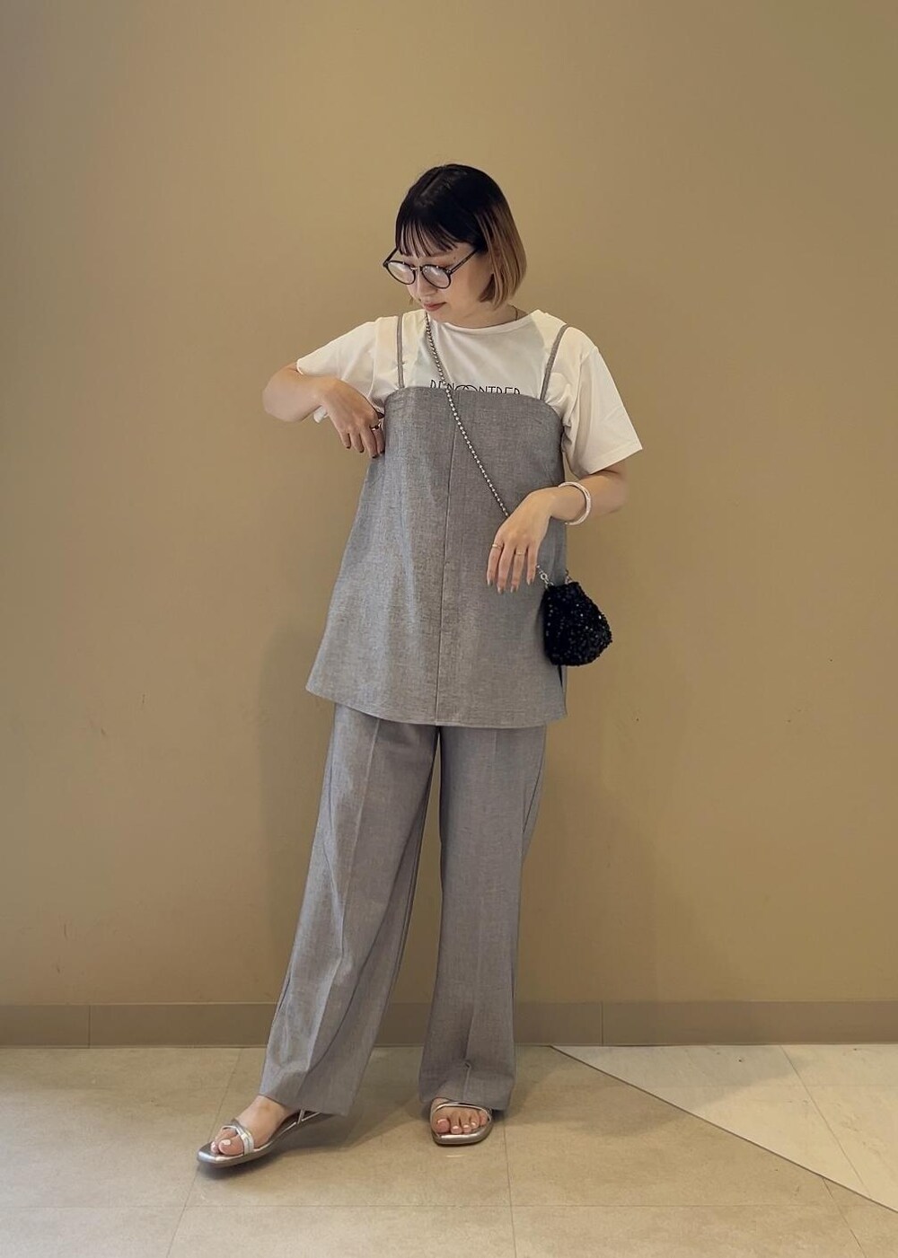 グレー系のキャミソール、ホワイト系のTシャツ/カットソー、グレー系のその他パンツを着用したレディースの春コーディネートの5枚目の写真