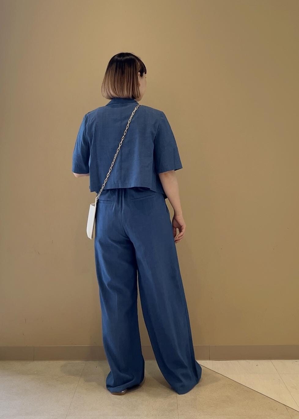 シルバー系のサンダル、ホワイト系のショルダーバッグ、ホワイト系のTシャツ/カットソーを着用したレディースの春コーディネートの3枚目の写真