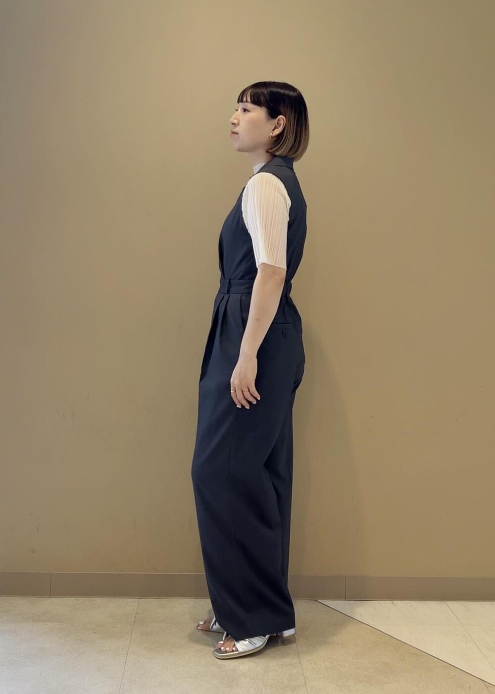 ブラック系のショルダーバッグ、ブラック系のサンダル、ホワイト系のTシャツ/カットソーを着用したレディースの夏コーディネートの3枚目の写真