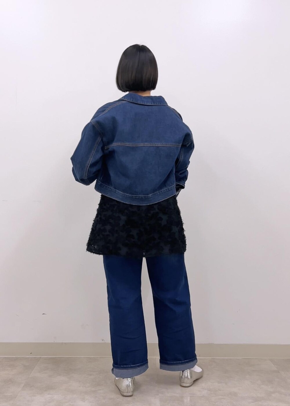 ブラック系のキャミソール、ブルー系のデニムジャケット、ホワイト系のTシャツ/カットソーを着用したレディースの冬コーディネートの2枚目の写真