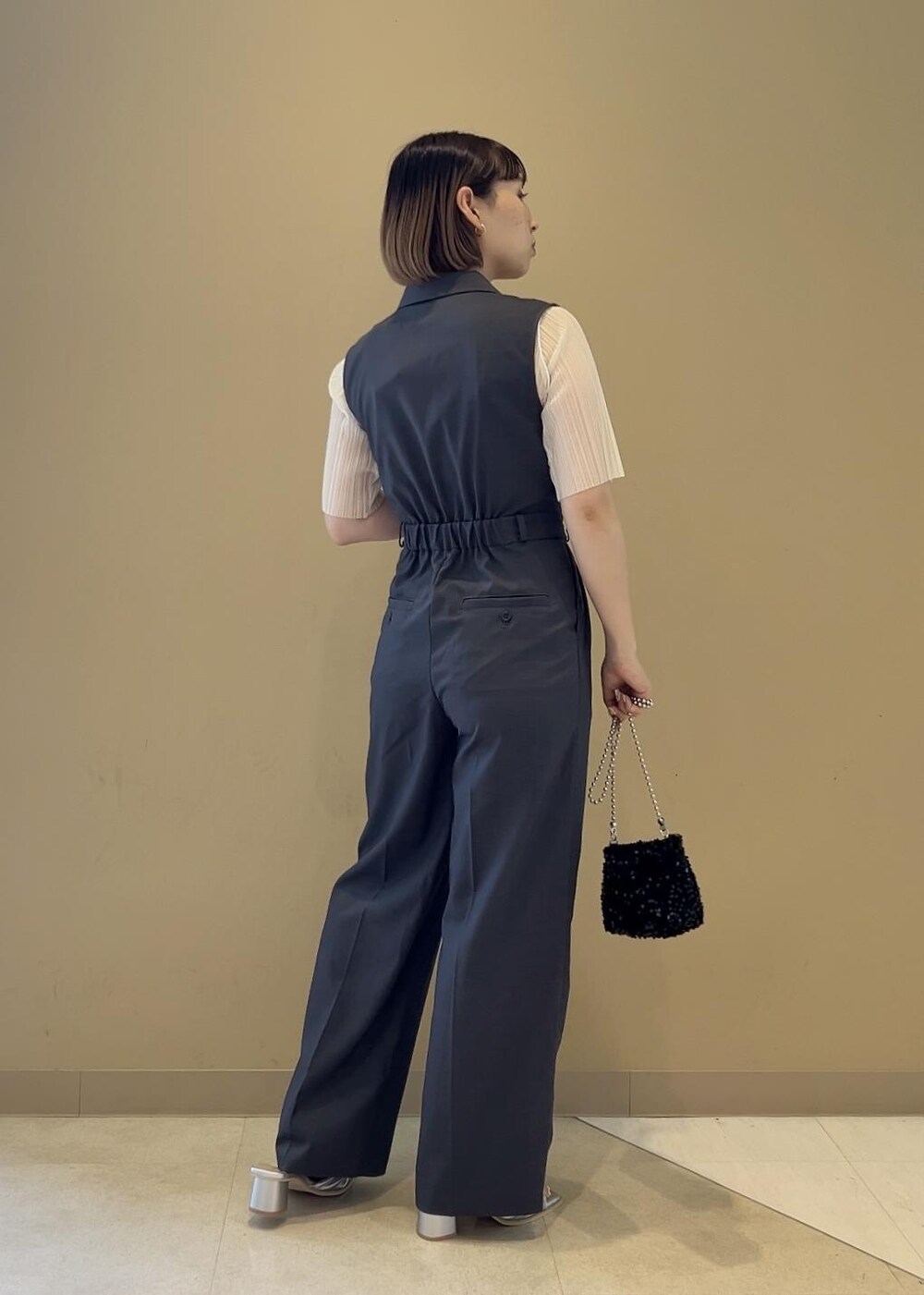 ブラック系のショルダーバッグ、ブラック系のサンダル、ホワイト系のTシャツ/カットソーを着用したレディースの夏コーディネートの2枚目の写真