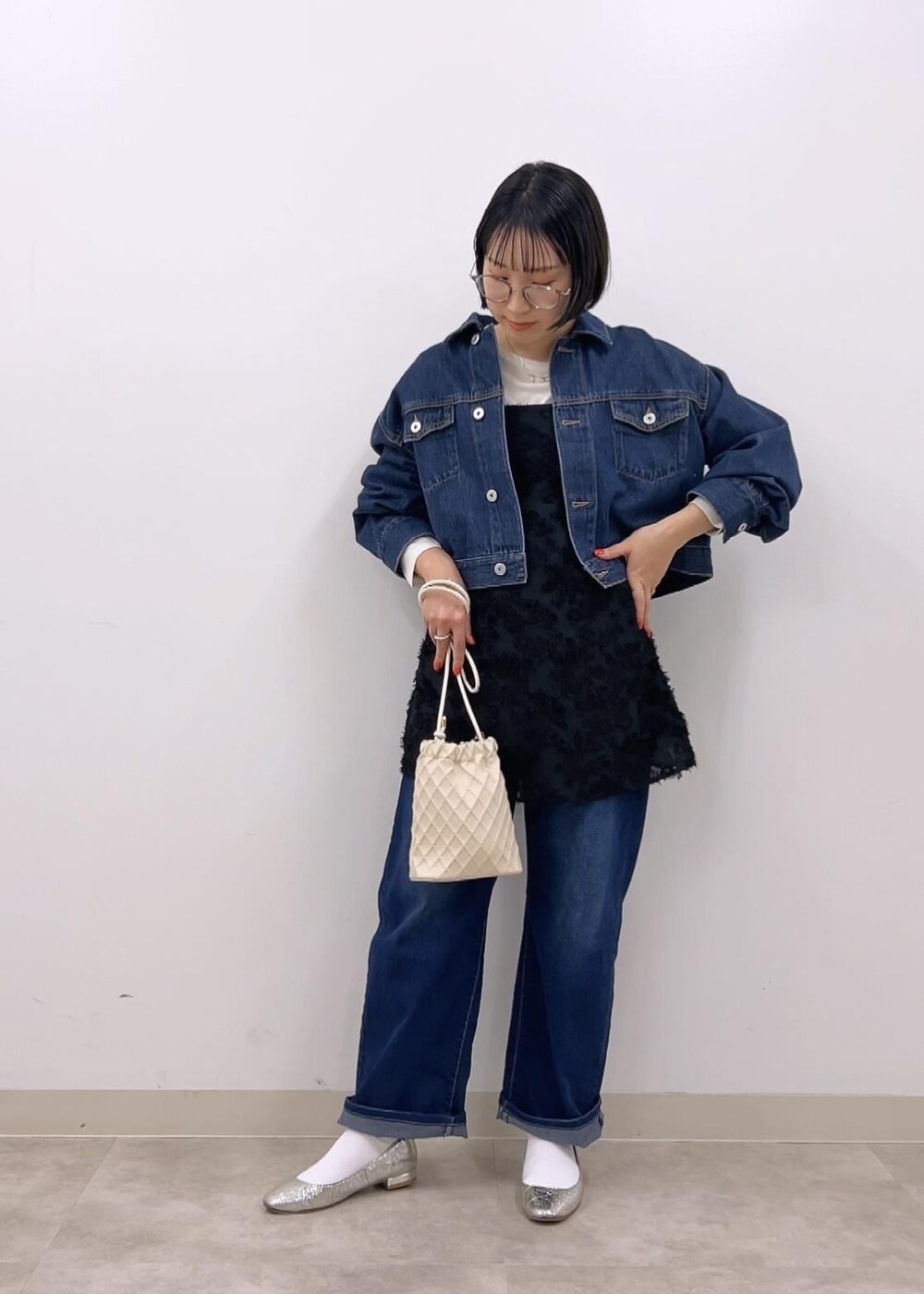 ブラック系のキャミソール、ブルー系のデニムジャケット、ホワイト系のTシャツ/カットソーを着用したレディースの冬コーディネートの4枚目の写真